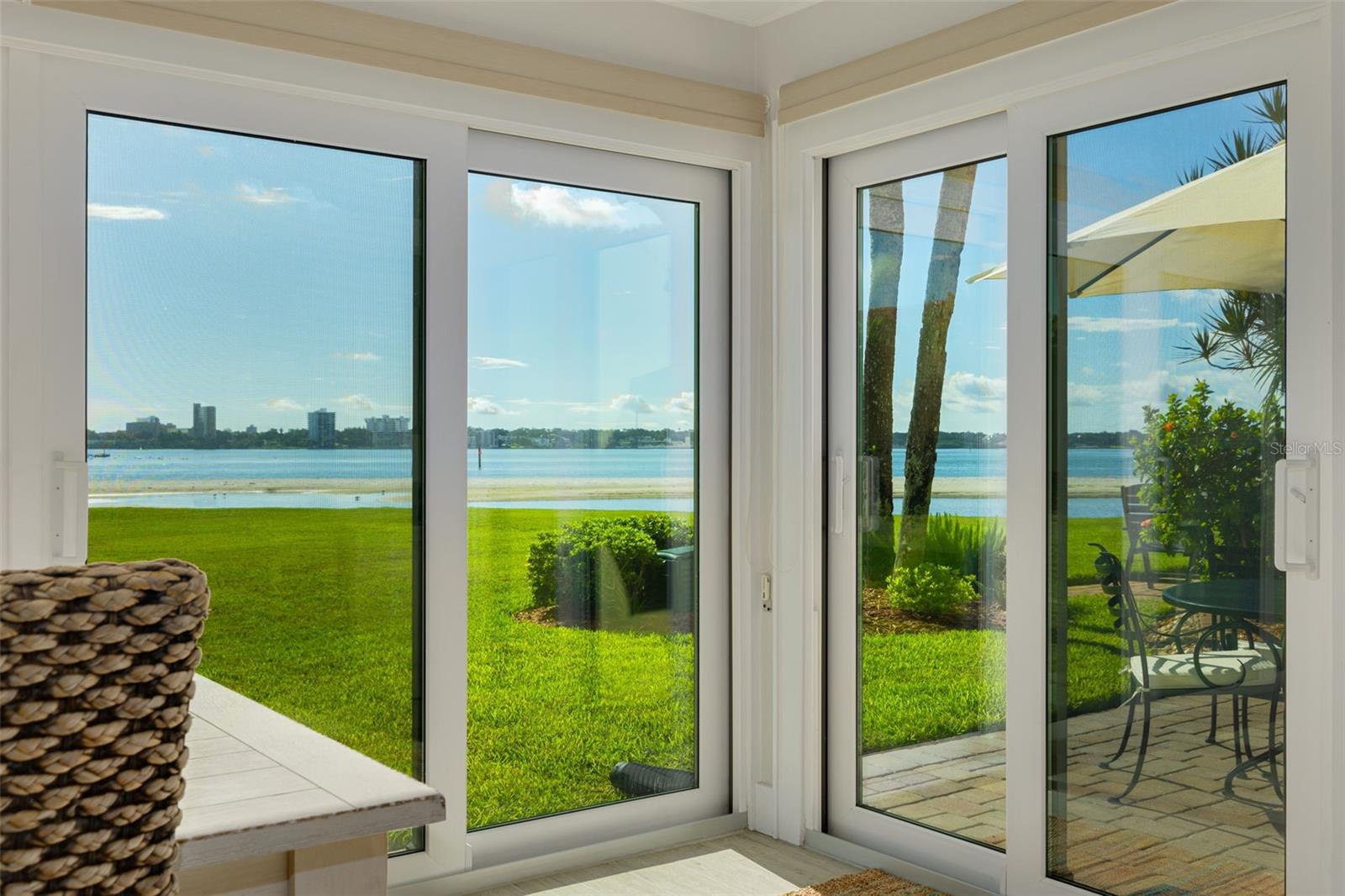 Panoramic Intracoastal and Clearwater skyline views, with dolphin sightings and boats heading out to open water, greet you from this beautifully renovated and furnished turnkey 2 BR / 2BA first floor, southeast-facing residence on the southern shore of Clearwater Beach.  Set in the Gulf House at Clearwater Point, this split-plan condominium blends high-end finishes with an unbeatable coastal location in a well-maintained, amenity filled three-story building complex.Continuous porcelain tile is complemented by Armstrong WoodHaven ceiling planks and five upgraded ceiling fans (2024). Solid wood doors and trim throughout, louvered closet doors, and keyless entry. All windows and sliders are hurricane impact-rated (sliders replaced 2025) with custom-fitted coverings.  Sliders open to a private paver patio and green space with direct beach access.The kitchen features solid wood soft-close cabinetry with pull-out drawers, quartz countertops, glass subway tile backsplash, and a pantry. Stainless steel appliances includes a newer Whirlpool refrigerator (2025). A custom laundry cabinet houses new (2026) GE front-load compact HE stackable washer with matching ventless dryer.The primary suite offers dual closets, patio access, and an en suite bath with solid wood cabinetry, quartzite countertops, and a custom porcelain tile shower. The second bathroom also features solid wood cabinetry and quartzite countertops, with tile surrounding the tub. Additional storage includes an entry closet with custom glass doors and a hall closet with built-in shelving.Other updates include HVAC (2019), water heater (2023), plumbing (2024), and electrical panel (2025). The condo includes covered reserved parking and private storage locker. Sold fully furnished, including two televisions, kitchenware, linens, and all finishings, so the buyer can move in immediately. Clearwater Point offers expansive private waterfront with beach access, three heated pools and a spa, pickleball, tennis, and shuffleboard courts, and beachfront grills, a picnic area, and a fire pit. Easy access to Tampa International and St. Pete-Clearwater airports, boating, golf, and area attractions, with walkability to dining and shopping.