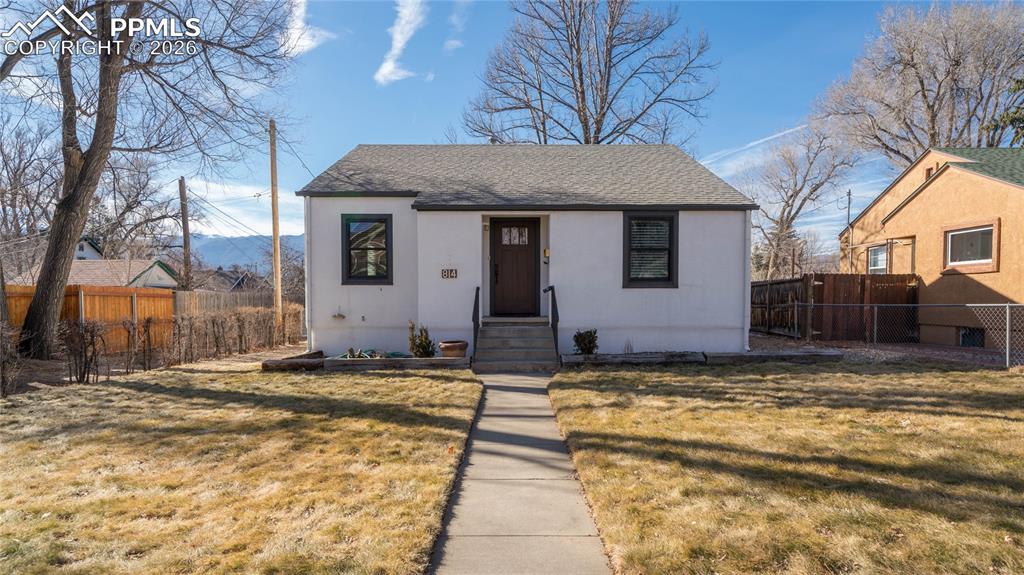 This 4-bedroom, 2-bathroom ranch home offers the perfect blend of classic character and thoughtful updates on a quiet street in downtown Colorado Springs. You'll enjoy convenient access to shopping, schools, and nearby hospitals while living in an established neighborhood. The main level welcomes you with beautiful hardwood floors flowing throughout the living spaces. Thoughtful details include built-in cabinetry and elegant coved ceilings that add timeless charm. The combination living and dining room provides flexible space for everyday living and entertaining. The current owners have invested in meaningful improvements including completely remodeled bathrooms, new windows throughout for enhanced energy efficiency, and central air conditioning for year-round comfort. The stucco exterior provides low-maintenance durability. The fully finished basement expands your living space with two additional bedrooms, a large family room featuring built-in storage, and a remodeled three-quarter bathroom. This lower level offers versatility for guests, home office space, or recreation. The laundry room includes a practical utility sink for added convenience. Step out to a large covered deck where you can take in views of Pikes Peak—perfect for morning coffee or evening relaxation. The property includes a detached one-car garage, a two-car carport, and an additional cement slab for extra parking or storage. The lot is zoned R-2, offering potential flexibility for future use.