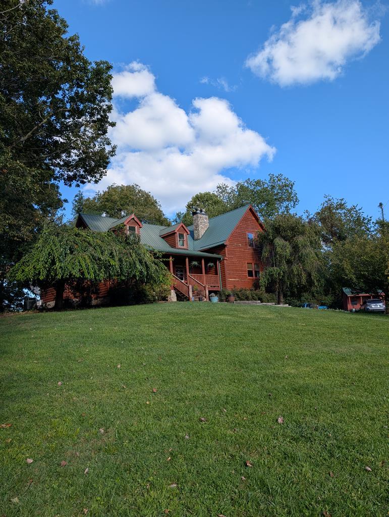 Mountain mini farm on 14+/- Private Acres.  A mix of fenced & open hay land with a 50X30 Metal barn with power & water & other useful out buildings, most with power, some with heat & water.  There are approximately 5-6 acres fenced & the survey shows a spring & stream down in the bottom back corner.  The remaining property lays so well it is mowed for hay.  There is one other spring on the property down by the road with some hardy gold fish in residence.  This kitchen is the heart of this home. Added on in 2007 with tall ceilings & windows allowing natural light to bath your work space and highlight the beautiful granite covering the expansive work space, eat-in island and counter tops.  Kraftmaid cabinets, an Induction Cook Top (cookware conveys), Bosch dish washer, a trash Compactor, all stainless, with room for many hands, to prepare what this mini farm could produce.  Keeping it easy inside, the laundry is on the main floor, the primary & 1 other bedroom with en suite full baths.   The master suite & living room share back to back wood burning fireplaces.  Built ins line the wall of the bedroom to house your favorite reads or collections.  The primary luxury bath has heated tile flooring, a soaking tub, step in tile shower with double heads.  After a days work or play shower off outside before soaking those sore muscles that are reminding you of what a great day you had, in the hot tub.  Both sunrise & sunset are amazing with a covered porch on the front and open decking out back.  Upstairs has 1 more bedroom,  family room 2 rooms & 2 baths.  The lower level has stackable W&D Hookups, 2 finished rooms, a 3/4 bath and the 2-car garage, utility & storage.   2-200 amp electrical panels feed the farm with power & a new, 8/2025, Siemens Generator helps keep it all going.  The Rannai tankless propane hot water heater was replaced in 2024.  If you want to escape to the mountains, make an appointment today.   You cannot see the home from the road, by appointment only.