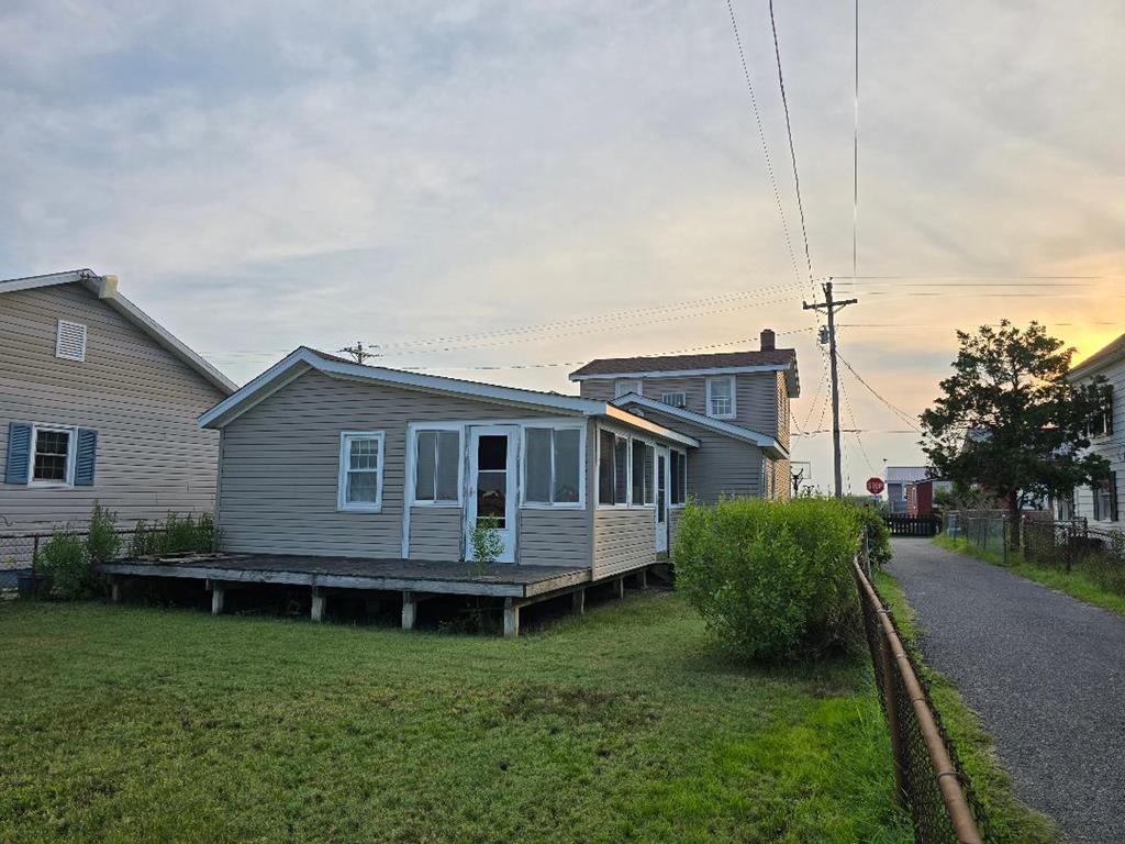 Circa 1900, Over the bridge through the waterways is the Fletcher House,  updated with traces of Tangier watermen's style. Country kitchen, sitting room, 1 full bath completed, and another full bath near completion. A bedroom on the 1st floor and a bright and cheery spacious bedroom on the 2nd. Enclosed front porch, with heat and air, massive enclosed sunroom adjacent to the kitchen, where you know many a yarn be told. Views of the waterways known as the ditches, where you can toss in your crab pot and expect to have enough by dinner time.  Huge deck too. Well-constructed garage, perfect for storing your golf cart, fishing gear, scooter, etc. The county indicates 1/4 acre conveys.. Minutes away is the mile-long beach, and town center as well..