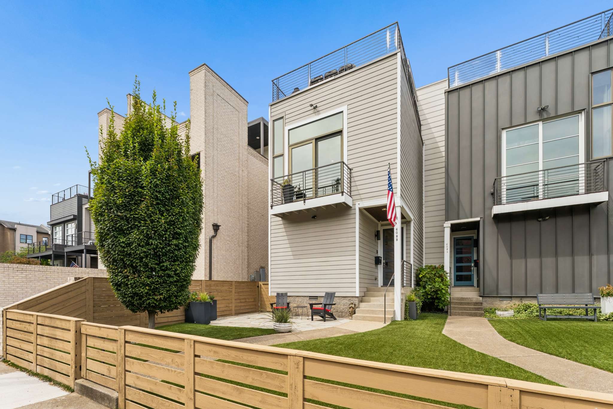 Welcome home! Neighborhood living, walk to 30+ restaurants, farmers market, etc and yet only minutes from all Nashville has to offer. A  must see! The MAIN LEVEL (level 2) offers stunning 10’, 12’, and 15’ ceilings with dramatic architectural elements that truly set it apart. The updated kitchen features an expansive granite island, and sits naturally between the unusually large flexible dining space and the dramatic living space. The luxurious primary suite boasts a 12' ceiling and sun-reflecting privacy windows at balcony. Completely renovated in 2022, the spa-like primary bath features a freestanding tub, heated tiled flooring, leathered granite vanity, an oversized 5' x 5' frameless zero-entry shower, and a custom California Closet. The THIRD LEVEL with spacious 10' ceilings offers a second primary ensuite bedroom (2 Queen beds+) with walk-in closet and beautifully appointed bath with heated flooring. The entertainment room with wet bar, quartzite countertop, beverage refrigerator, and abundant cabinetry complements the private partially covered rooftop oasis—perfect for entertaining or enjoying Nashville evenings.The LOWER LEVEL includes two additional bedrooms, Jack-and-Jill bath, laundry room, storage, and an impressive 4-car tandem attached garage with extensive built-ins, alley access, plus a rear parking pad for three additional vehicles. Additional highlights include first and second level hardwood floors refinished 2026, third level hardwood refinished 2022 all with a water-based commercial grade poly (will not yellow over time). New tankless water heater 2024, Turf and fenced front yard 2018. A truly distinctive Nashville residence blending luxury, versatility, and exceptional indoor-outdoor living. https://my.matterport.com/show/?m=yZcj8Gwe4DDAccess full list of Improvements & Amenities attached inc. Video URL here. Investors interested in double property opportunity please contact agent.   https://app.realkit.com/vid/608b-hume-street-nashville/br