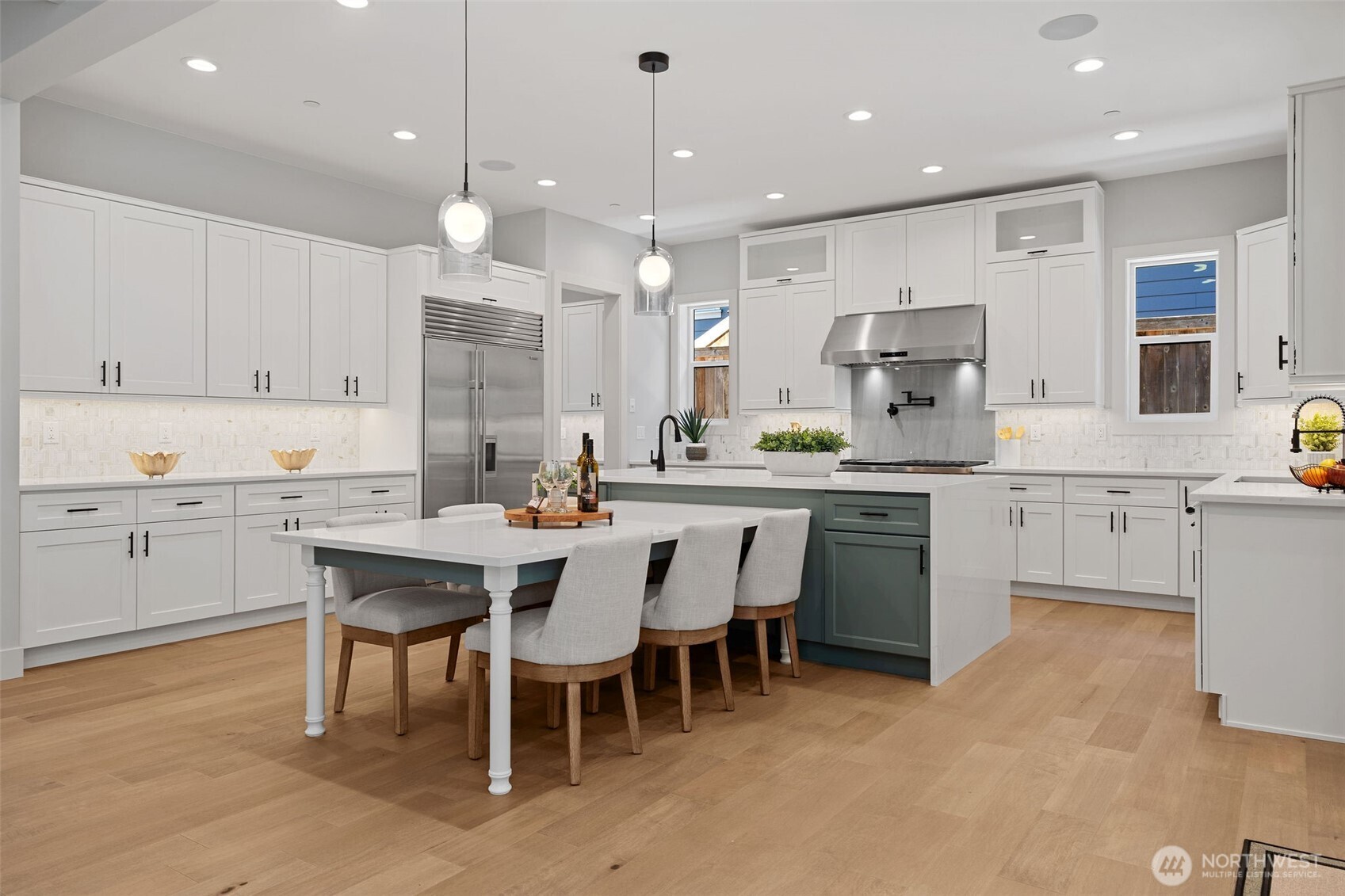 Storage is easy with a wall of custom cabinetry, and a Subzero refrigerator/freezer and a community table where everyone can gather at mealtime or for special   projects.