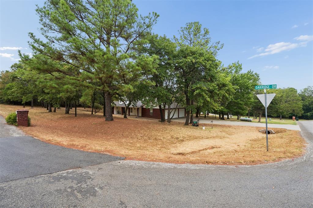 WOW WHAT A CHARMING HOME nestled in a Beautiful Treed Surrounding of over 2 Acres reflecting the Beauty of this Neighborhood! You will find the Care and Love this Home has received once you step inside. This 3 Bedroom, 2 Full Bathroom, Large Spacious Living Area with lots of Updates. Home has Tall Ceilings throughout, lots of Natural Light from Energy Efficient Windows with Nature Views. The Kitchen has great Cabinetry, Counterspace, Breakfast Bar and Newer Appliances. A large pantry is also Included. Inside Laundry Room with Plenty of Cabinets and a Folding Table. There is a Large Covered Porch and Covered Patio. The Home's Exterior is Maintenance Free Brick, Vinyl Soffit and Fascia. Newer Furnace, Water Heater, Water Well Pressure Tank and Regulator. Extra Deep 3 Car Garage! The Property has an Outbuilding and SHOPS are allowed in the addition. This is a MUST SEE PROPERTY!!