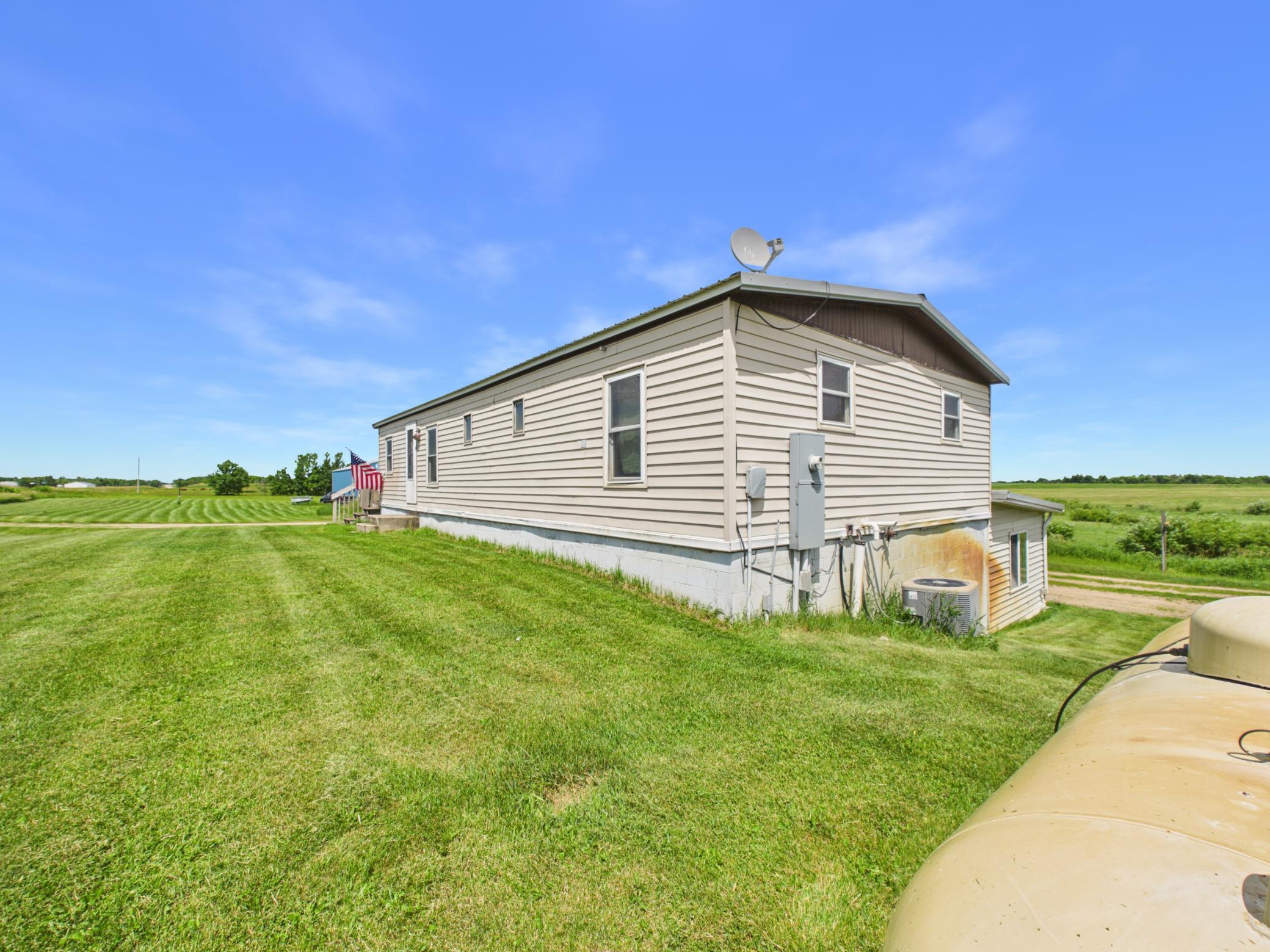 Secluded home on a level 5-acre lot featuring 3 bedrooms on one level, a gorgeous built-in bar area, 10' x 16' deck, and a 12’x20’ 3-season porch with a walk-out patio door. The property includes an impressive 40' x 56' heated shop with 16' sidewalls, two 14' x 14' overhead doors, a ½ bath, and a full steel interior—ideal for semi trucks, campers, equipment, hobbies, or entertaining. An additional 27' x 32' garage/shop with two 8' x 10' overhead doors provides even more storage and workspace. The home has a maintenance free steel roof.