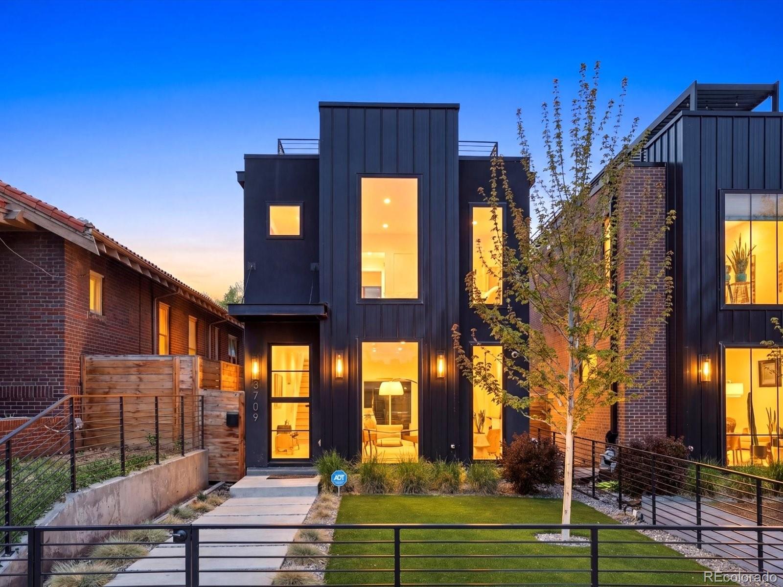 This ouse doesn't just offer a view, it captures all of them from this one-of-a-kind wraparound deck, while the interior brings some of the sleekest, and sexiest interiors LoHi has to offer. Don't settle for a duplex when you can have this striking single-family home that delivers a level of design that redefines what luxury living looks like in Denver. From the moment you arrive, the bold architectural façade and bespoke iron-and-glass entry set an unforgettable tone. Inside, Pinky’s custom-crafted front door opens to soaring ceilings, newly finished hardwood floors, and a statement gas fireplace anchoring a light-filled, open-concept living space designed to impress. The showpiece kitchen features a dramatic 14-foot waterfall quartz island, premium Ilve range and Dacor appliances, a walk-in pantry, built-in coffee bar, wine fridge, and moody under-cabinet lighting. A fully-collapsible door blur the line between indoors and out, opening to a private backyard, while a thoughtfully designed mudroom/drop zone enhances everyday functionality. Upstairs, the primary suite offers a serene, spa-inspired escape with heated marble floors, a freestanding soaking tub, multi-head shower, dual vanities, and walk-in closet. A secondary suite provides additional comfort and privacy. A custom iron spiral staircase leads to an extraordinary rooftop bar and office space, wraparound rooftop deck (engineered for a hot tub) where panoramic 360° views of the Denver skyline create the ultimate setting for sunset soirées and unforgettable entertaining. The fully finished basement adds versatility with generous space perfect for a gym, media room, game room, or lounge, along with a wet bar, additional bedroom, full bath, and ample storage. All just moments from LoHi favorites like El Five, Linger, Alma Fonda Fina, Gaetano’s, and Steam Espresso, with easy access to the best of Denver.  This is elevated LoHi living, without compromise.