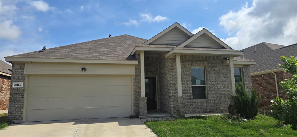 Single story home with a garage, brick siding, and driveway