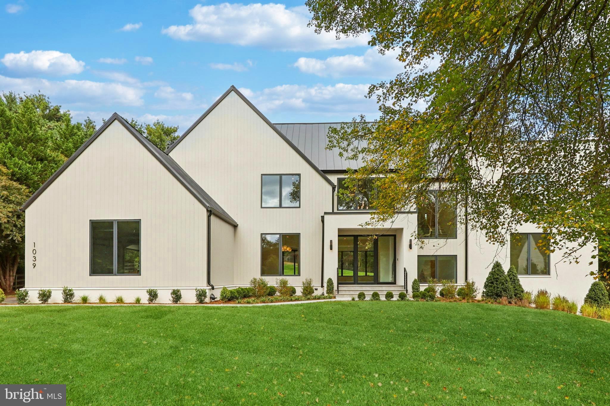 Nestled in the heart of Great Falls, this modern transitional masterpiece, designed by Harrison Design and constructed by Palladio & Co., offers an unparalleled living experience. With a dynamic, open floor plan bathed in natural light, it effortlessly blends traditional elegance with contemporary convenience.  Spanning approximately 9,545 square feet across three meticulously finished levels, this architectural gem is a designer’s dream, featuring state-of-the-art finishes and thoughtfully curated details throughout.As you step inside, your eyes are naturally drawn through the space, guiding you toward the level manicured green lawn at the back. The grand two-story vaulted foyer is highlighted by a sculptural curved-rail staircase and elegant designer lighting, setting the tone for the entire home.  The kitchen is a chef’s delight, featuring a statement 48” AGA range, paneled appliances, and a striking stone island, with a spacious scullery kitchen designed for prep work. The great room, centered around a linear gas fireplace with a floating hearth, creates a cozy and inviting atmosphere. The sun-soaked casual TV/morning room features floor-to-ceiling retractable glass sliders, seamlessly blending the interior with the outdoor living space and framing views of trees and nature. The expansive covered outdoor areas and patio are perfect for both intimate evenings and seasonal gatherings, with the potential to add a pool, spa, grill station, outdoor fireplace, or fire pit. The main level also features a formal dining room, a luxurious owner’s suite with a spa-inspired bath complete with a dual sink vanity and Graff fixtures, a home office, and a convenient mudroom leading to the oversized attached three-car garage with two EV chargers, adding both function and elegance to the space.On the upper level, the exceptional primary suite offers a serene sanctuary with a freestanding soaking tub, a curbless glass-enclosed shower with fluted tile, and heated radiant floors. Multiple walk-in closets and a dedicated makeup center complete this retreat. This floor also includes three additional ensuite bedrooms, each with custom tile baths, a laundry room and abundant storage for linens.The lower level is designed for relaxation and entertainment, featuring an open recreation room with ample natural light and easy access to the yard. The full wet bar, complete with a tall wine cooler and refrigerator, sets the stage for hosting, while the separate gym/exercise room provides an ideal space for fitness. The home theater or optional golf simulator room is pre-wired and ready for enjoyment and a private ensuite craft room (or 6th bedroom) adds the finishing touch to this floor. An optional elevator can also be added for convenience.  Every detail has been thoughtfully crafted, with custom design elements throughout.  This exceptional home offers the perfect balance of serene living in Great Falls with easy access to fine dining, shopping, and more.  Prospective buyers are encouraged to reach out to Listing Team to inquire for further information about the distinctive features and key specifications of this remarkable property and schedule a tour.  Make sure to refer to the Documents section for th eBrochure and Floor Plans.