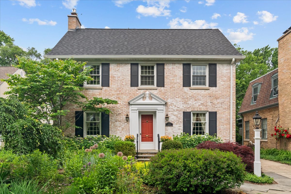 Nestled in one of Evanston's most treasured neighborhoods, this brick center-entry Colonial offers a gardener's paradise, lovingly tended to with an impressive array of plants that bloom throughout all seasons. Every corner of this home reflects the care and attention of a perfectionist, from its impeccable landscaping to the well-maintained interiors. A welcoming blue stone walkway leads you to a traditional home with classic architectural details. Inside, the dining room boasts an elegant corner cabinet, while the sunny and inviting living room features a handsome mantle and a gas fireplace. Hardwood floors flow seamlessly throughout the main level, where a center hallway connects a beautifully updated kitchen, a cozy powder room, and a bright eating area. The family room addition at the back of the house offers breathtaking views of the lush backyard gardens, pergola, and lawn, perfect for both relaxation and entertaining. Each room has been thoughtfully designed to blend comfort with style, creating a space you'll love to call home. Upstairs, the primary suite features an updated ensuite bath, while two additional family bedrooms share a hall bath. The third-floor artist's studio is a true highlight, boasting skylights, extensive built-ins, and a spacious walk-in closet. This versatile space could easily serve as a fourth bedroom, home office, or creative retreat. The paneled lower-level rec room includes a gas fireplace, an office, and a powder room, with ample storage and a separate laundry area in the utility room. This home also features an impressive list of recent updates, including a new roof, furnace, air conditioning system, and water heaters.