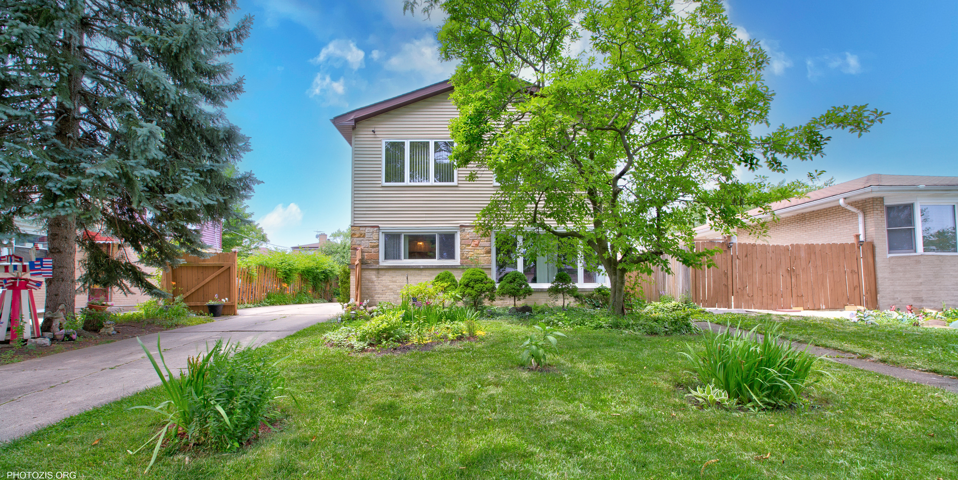Welcome to this beautifully maintained split-level home offering over 2,200 sq ft of thoughtfully designed living space. Featuring 4 bedrooms, 3 full bathrooms, and a detached 2-car garage, this home provides both comfort and versatility for today's lifestyle.  Step inside to a bright and airy open-concept main level, perfect for entertaining. The expansive living room flows seamlessly into the kitchen and dining area, where you'll find granite countertops, stainless steel appliances, and a large island that doubles as a breakfast bar. Upstairs, the second level includes three spacious bedrooms and a full bathroom complete with double sinks, granite counters, and a soaking tub. The private third-floor master suite is a true retreat-featuring vaulted ceilings, two walk-in closets, and a luxurious en-suite bath with granite double vanity, jetted tub, and a walk-in shower.  Beautiful hardwood floors run throughout the main living areas and all bedrooms. The lower level offers a cozy family room, a full bath with walk-in shower, a laundry room, and a bright sunroom with access to the backyard.  Enjoy your own garden oasis in the fully fenced backyard, complete with vegetable beds, fruit trees, flowers, grapevines, and a stunning patio deck-ideal for outdoor gatherings and relaxation.