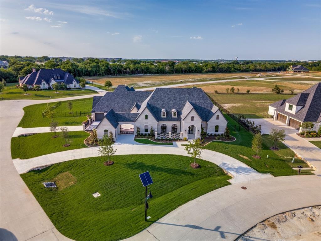 Stunning new custom home by one of DFW’s premier luxury builders, where no detail has been overlooked. This smart home is equipped with Lutron automation, pre-wired for electric shades, in-ceiling speakers, fully wired media room for projector, screen, ready for equipment of your choice. The striking buff Lueders stone exterior—a $400K upgrade, compared to the average standard stone, adds timeless beauty and unmatched durability.

Enjoy resort-style living with a large pool, hot tub, water features, upgraded in-ground cleaning system, artificial turf, and a private courtyard. Two separate entrances to the gated driveway, circular drive with full landscaping. The upscale chef’s kitchen features a massive island with Cristallo Quartzite waterfall edge, a 48” Wolf gas cooktop with griddle, double Wolf ovens, drawer microwave, built-in 36 in. refrigerator and freezer columns with custom cabinetry, built-in coffee maker, full-size wine fridge, butler’s pantry, and an oversized custom walk-in pantry.There is even a set of double fridge drawers under the coffee maker, for added convenience. Outdoor kitchen on the large covered patio has a masonry fireplace, built in gas grill with commercial vent, refrigerator, and a custom drop space for a smoker of your choice.

Thoughtful extras include a dog wash in the laundry room, epoxy coated garage floors, enclosed garage storage with shelving. The home offers five spacious bedrooms, each with ensuite baths and walk-in closets. The primary suite includes dual closets, one with a secondary laundry, and a smart toilet washlet. Additional highlights: a dedicated exercise room with access to the primary suite and a hidden safe room concealed behind a bookshelf in the office.