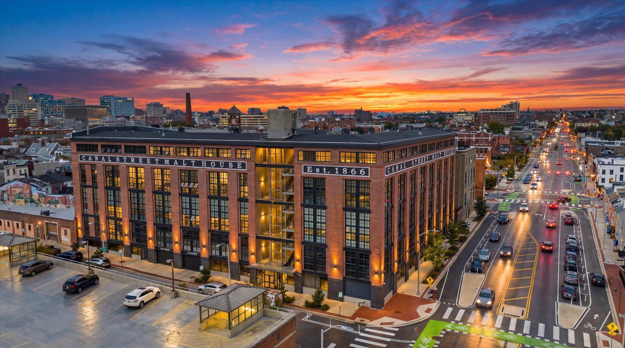 There’s a certain ease to life here, where light pours in, the city feels within reach, and every detail has been thoughtfully considered.Ideally located on the fourth floor of the Canal Street Malt House, this residence is defined by its dramatic floor-to-ceiling windows, framing captivating views of the Harbor East skyline. From morning light to evening glow, the home is constantly shifting in the most beautiful way; bright, open, and effortlessly inviting.The main level is designed for both everyday living and entertaining, anchored by a chef’s kitchen complete with a Wolf range, wine refrigerator, and an expansive island that naturally becomes the heart of the home. A main-level ensuite bedroom offers flexibility and comfort, whether for guests or a more private retreat.The second-floor primary suite feels like its own quiet escape. Lofted and open, yet deeply private. Thoughtfully scaled, it features an expansive walk-in closet and a spa-inspired bath with a soaking tub, creating a place to truly unwind at the end of the day. Just beyond, a spacious balcony overlooks the building’s landscaped courtyard; an unexpectedly serene backdrop in the middle of Little Italy. Throughout, generous proportions set this residence apart as one of the larger floor plans in the building, offering a sense of space that’s increasingly rare in city condo living.Garage parking with one assigned space adds a layer of convenience to an already elevated lifestyle.See why the Canal Street Malt House is one of the most coveted addresses in Baltimore. In the heart of Little Italy, a few blocks from Harbor East, waterfront promenades, and some of Baltimore’s most beloved dining destinations, this is city living at its most refined.