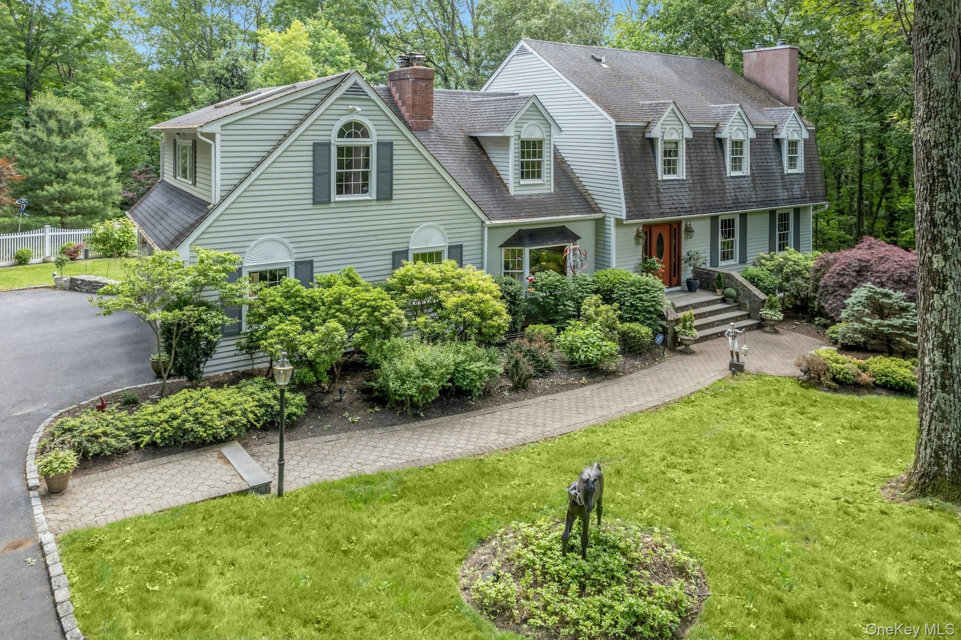 Sprawling colonial where tranquility meets sophistication. Imagine spending the summer relaxing or entertaining poolside on this stone patio, set on over 2 acres of rolling landscape with mature gardens, all surrounded by protected land.  The interior opens to a generous foyer, a formal living room w/fireplace, formal dining room and large sunken family room with custom woodworking, a fireplace and wet bar. The kitchen is equipped with high end appliances, granite countertops, a breakfast nook, and includes sliders to a large deck. 4 bedrooms are located on the second floor.  The primary suite has a fireplace, ensuite bath, and generous closet space; w/d conveniently located down the upstairs hall. Vaulted ceilings and lots of windows fill the game room with abundant natural light, and add architectural interest to the space. A total of 3700 square ft of living space completes the main living quarters. The lower level features an additional  1100 square foot of living space with a legal kitchen, playroom, full bath and separate washer/dryer.  Located at the end of a cul-de-sac, convenient access to highways, parks, trains and shopping in multiple neighboring towns.  Bedford Schools. A must see to truly appreciate all that this listing has to offer!