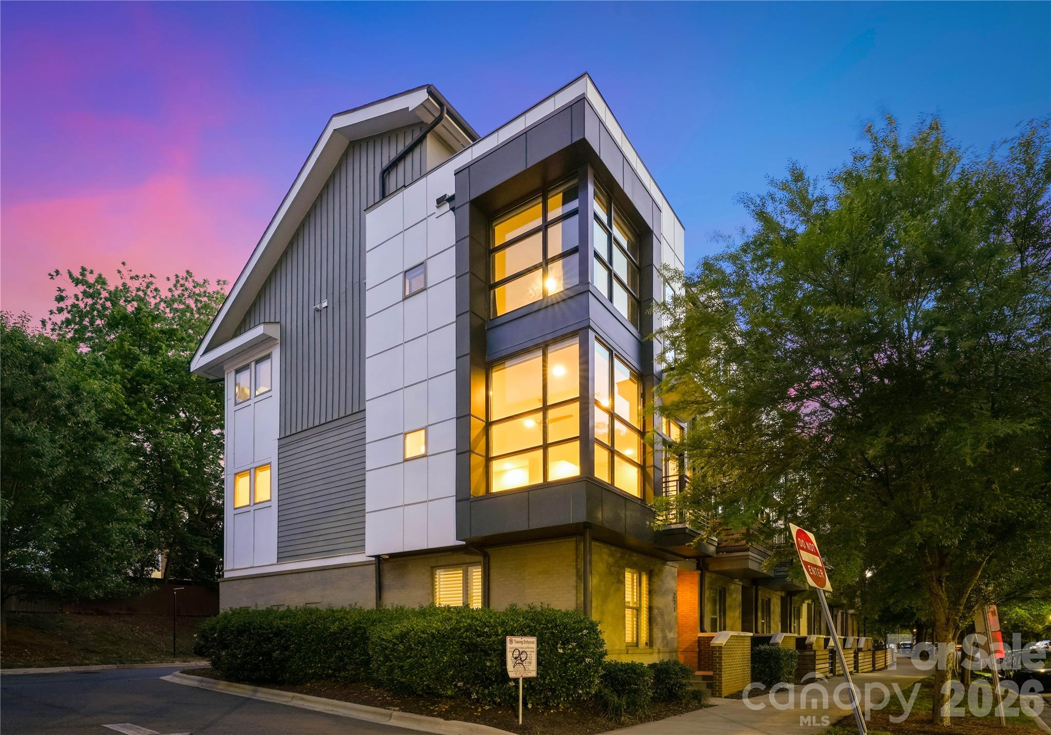 One of only four end units at Helix South End Townhomes, this truly one-of-a-kind 3 bed, 3.5 bath property offers an unparalleled opportunity in the heart of South End. Perfectly positioned in an unbeatable location, this sophisticated townhome delivers a seamless blend of modern design, privacy, and refined living. The home is appointed with hardwoods throughout—no carpet in bedrooms—and statement plantation shutters that elevate both style and privacy. The open-concept living space is designed for effortless entertaining, centered around a chef-inspired kitchen with an oversized island, custom-quality cabinetry, stainless steel appliances, designer backsplash, and a dedicated wine bar with double pantry storage. Striking floor-to-ceiling windows define the home, flooding the interiors with natural light and creating a dramatic yet inviting atmosphere. Thoughtfully curated modern lighting and clean architectural lines enhance the home’s contemporary elegance throughout. Enjoy the convenience of a two-car side by side garage with epoxy floors and the exclusivity of a rare end-unit setting. Elevate your lifestyle on the private rooftop terrace with long range views of South End! This is luxury urban living at its finest—distinctive, refined, and perfectly placed in the center of it all.