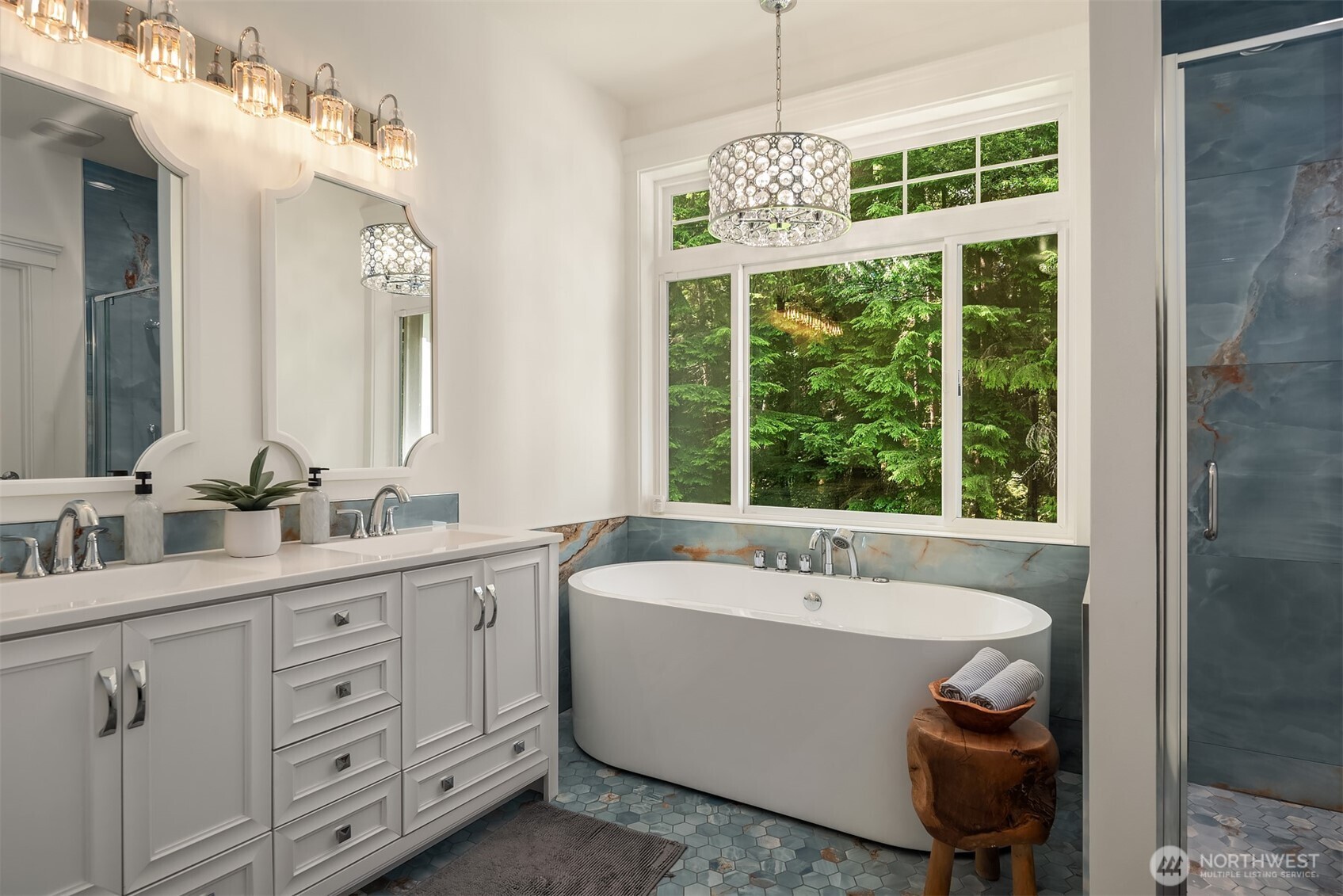 Spa-inspired primary bath featuring a soaking tub, dual vanity, oversized shower, and tranquil forest views.