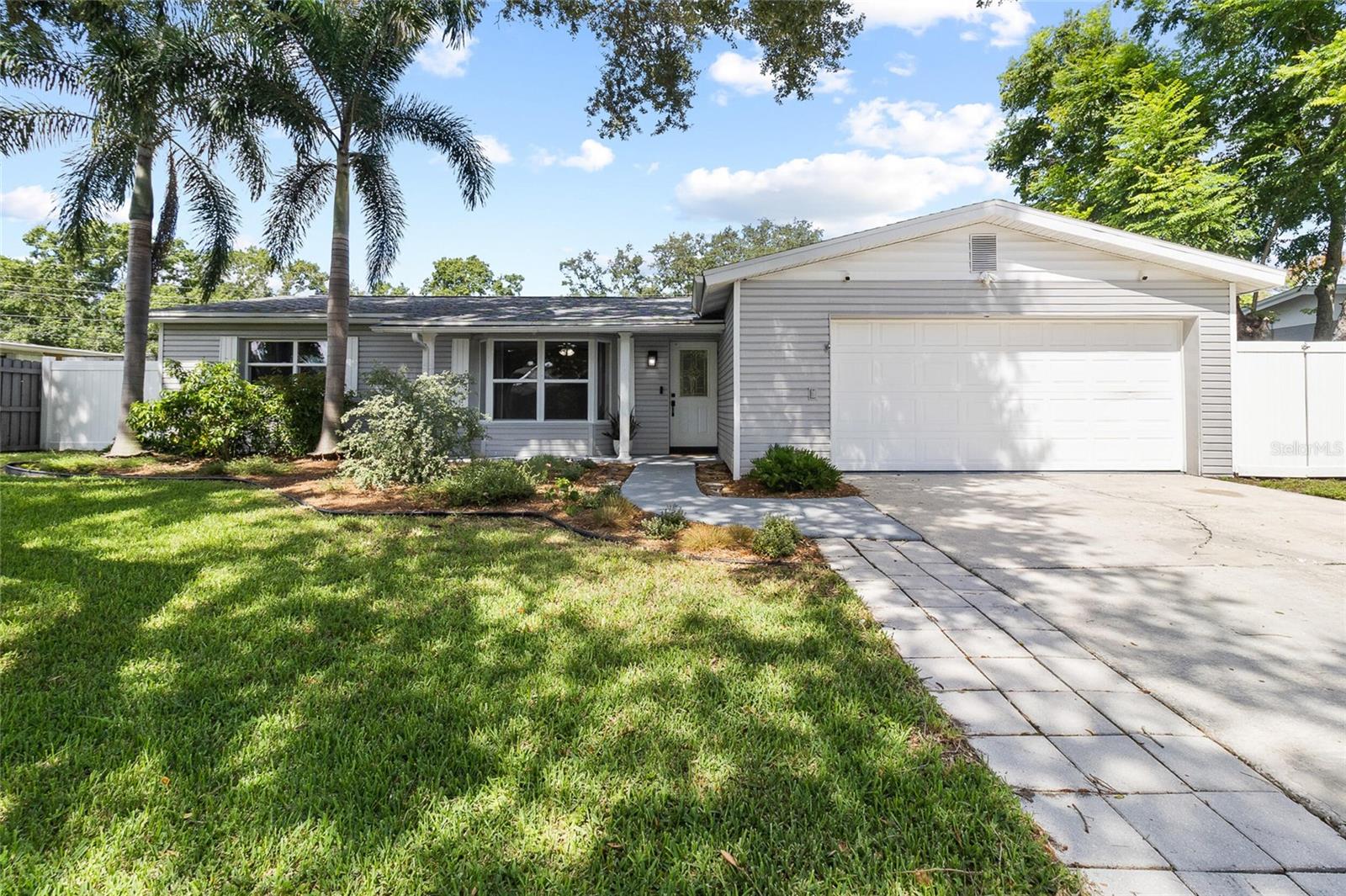 Welcome to 11290 116th St, where a backyard gate opens directly onto the paved, 45-mile Pinellas Trail. Walsingham Park is within walking distance, and Indian Rocks Beach is about a 10-minute drive.The major systems are already updated: a new roof (2022), new windows (2023), and an HVAC system that was recently professionally cleaned, sanitized, and paired with new attic insulation. The open-plan kitchen has freshly painted cabinetry, new hardware, granite-look countertops, and stainless steel appliances. Wood-look flooring and crown molding run throughout, with a ceiling fan in every room.  The family room features a wood-burning brick fireplace that anchors the space. A hybrid water heater (2023) and a whole-home Springwell CSS4 filtration system (ready to connect) are also included.Outside, a paver patio wraps the home within a fully fenced yard. A mature, regularly maintained oak tree and swaying palms shade the front yard, alongside native, pollinator-friendly landscaping designed by Wilcox Nursery — butterflies are a regular sight — plus drip irrigation up front for easy upkeep.This is a home where trail access, established landscaping, and major updates all come together — ready for its next owner.Please note: this property is equipped with video and audio surveillance/recording devices in and around the home.