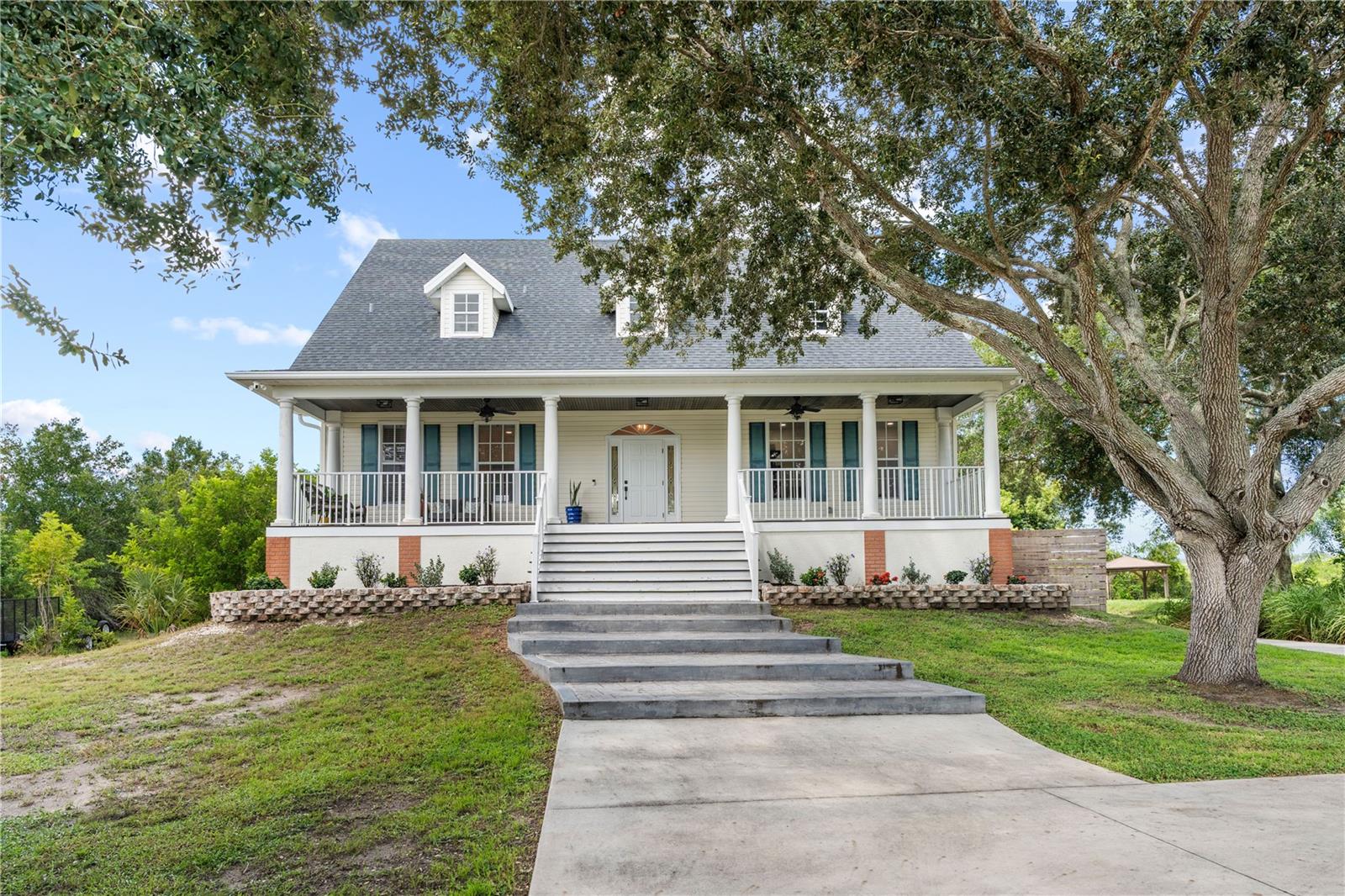 Welcome to this beautifully updated four-bedroom, four-bathroom waterfront home offering 3,069 square feet of thoughtfully designed living space on an almost two-acre lot. Set in a peaceful, nature-filled waterfront setting, this property offers a rare combination of privacy, space, water views, and extensive updates throughout. A long driveway leads to the home, while a community boat ramp is conveniently located just one street away. The home has been updated from top to bottom, including new flooring, remodeled bathrooms, updated lighting and fixtures, and new ceiling fans throughout. Additional major improvements include a 2022 roof and water heater, while the AC has been routinely maintained. Inside, a welcoming foyer opens to a spacious living room with high ceilings, wood-look luxury vinyl plank flooring, a fireplace, and French doors leading to the expansive balcony porch overlooking the water. The open kitchen and dining area is truly the heart of the home, featuring quartz countertops, abundant cabinetry, a large island for dining and prep, stainless steel appliances, a gas range with a convenient pot filler, and a farmhouse sink. Just off the kitchen, the updated laundry room provides even more cabinetry and storage. A dedicated downstairs office offers a quiet space for work or study. The primary suite is conveniently located downstairs and features two walk-in closets and French doors opening directly to the balcony porch. The spa-like primary bathroom has been beautifully remodeled with a double-sink stone-top vanity, updated mirrors, lighting and fixtures, a soaking tub, and a separate shower featuring three shower heads. Upstairs, three additional bedrooms each offer walk-in closets, along with two beautifully updated full bathrooms—one with a tub/shower combination and the other with a step-in shower. Both feature beautiful tilework, updated vanities, mirrors, and lighting. A spacious loft area adds additional flexible living space, while generous storage throughout the home makes it easy to stay organized. Outdoor living is just as impressive, with a huge front porch, expansive rear balcony porch, and a covered downstairs patio providing multiple places to relax and take in the peaceful waterfront surroundings. The oversized garage offers room for up to six vehicles and plenty of additional storage or workspace. The location is equally appealing, close to the historic Tarpon Springs Sponge Docks, an array of dining options, shopping centers, and multiple golf courses, while still offering the tranquility of a spacious waterfront property surrounded by nature. Schedule your tour today!