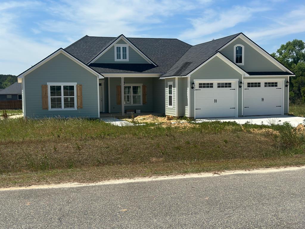Stunning new construction nearing completion with upscale finishes, including laminate hardwood flooring throughout and an oversized two-car garage and mudroom with cubbies for backpacks and shoes to keep everyone organized, a kitchen with ample cabinet space, a bar for barstools, hard surface countertops and a beautiful tile backsplash. large, vaulted living room that opens to a covered patio for seamless indoor-outdoor living. The primary bedroom also features vaulted ceilings and a barn door opening to the primary bathroom with extra-large double vanities and a luxury tile shower with two showerheads, plus an extended walk-in closet. The home also offers three additional bedrooms and a full bath in a split floor plan for privacy. Walk -in laundry with a linen closet and double vanities.
