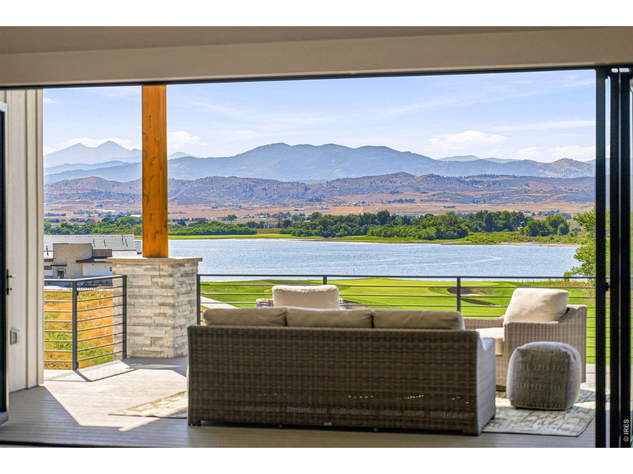 Welcome to your home sanctuary. This exceptional 4-bed, 5-bath home is an entertainer's paradise offering panoramic views of Lone Tree Reservoir, Long's Peak, and the Front Range. Positioned on the 9th fairway of TPC Colorado with direct access to lake living, this residence seamlessly blends luxury, functionality, and Colorado's natural beauty. Step inside to soaring ceilings with custom beams and inlays that frame expansive mountain views from nearly every room. Rich Hacienda hickory floors ground the sophisticated open floor plan flooded with natural light. The gourmet kitchen features a complete Thermador appliance suite, custom cabinetry, walk-in pantry, and views to match the finest restaurants. The dramatic 15-foot NanaWall dissolves the boundary between living space and nature, opening the main living area to a covered deck-arguably the best vantage point in the neighborhood for sunset over the reservoir and mountain peaks. The dedicated home office with built-ins and the guest suite with private bath offer versatility for modern living. Your private retreat features a luxurious ensuite with a massive walk-in shower, free-standing soaking tub, dual walk-in closets, and those signature mountain views. Five thoughtfully appointed bathrooms serve the home with spa-like finishes. The full wet bar in the walk-out basement-complete with wine storage, refrigeration, and ice maker-flows into a hobby room with sink and built-in cabinetry overlooking the fairway and lake. An outdoor kitchen on the main floor deck and a custom natural gas firepit on the lower patio create an idyllic alfresco gathering space. Located in one of Colorado's most coveted communities, this home sits steps from the Waterfront Grill restaurant and direct beach access to the lake. The neighborhood offers: walk to the lake beach, world-class golf, hiking trails, and water sports. Close to Everything: Minutes to Boulder, Longmont, and I-25, yet worlds away in serenity.