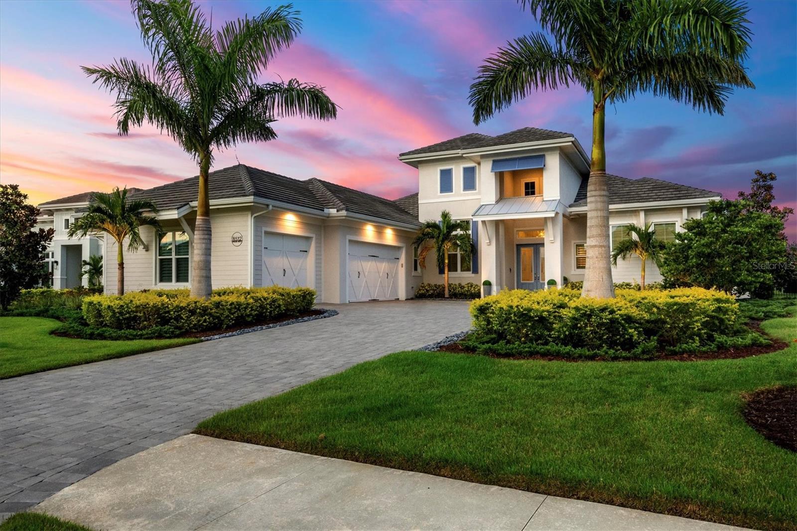 Under contract-accepting backup offers. Within the prestigious gates of The Lake Club, this stunning 4-bedroom, 5.5-bathroom estate with a private casita/bonus room and dedicated office embodies the pinnacle of elegance and resort-style living. Positioned on a serene lake with no neighbors behind, the home offers privacy and sophistication. From the moment you arrive, the paver driveway, mature landscaping with accent lighting, and a 3-car side-load garage set the tone for the refined lifestyle within. Step through the double-door entrance into a thoughtfully designed open floor plan with soaring ceilings, IMPACT GLASS windows and doors, and seamless indoor-outdoor living. The great room boasts 14-foot custom wood ceilings, 12-foot sliding doors, tile plank flooring, and custom built-ins, while the chef’s kitchen dazzles with stainless steel appliances, wall oven with convection, microwave, oversized island, dry bar, quartz countertops, and a walk-in pantry with wood shelving. The primary suite is a private retreat with double glass doors opening to the lanai, remote-controlled shades, custom closets and a spa-like bathroom featuring a walk-in shower, soaking tub, split vanities, and quartz countertops. Each additional bedroom includes an en-suite bathroom, ensuring comfort and privacy for family and guests. A highlight of the home, the casita/bonus room offers a private double-door entrance, en-suite bath with walk-in shower, quartz counters, wet bar with wine refrigerator, and remote-controlled shades—ideal as a guest suite, media room, gym or retreat. The den/study impresses with double glass doors and custom built-ins. The outdoor living area is designed for entertaining and relaxation. A panoramic screen frames sweeping water views, while the expansive lanai features a custom wood ceiling, tile deck, gas fireplace, outdoor kitchen with gas grill, wet bar, and refrigerator. The heated saltwater pool with sun shelf, infinity-edge spa, and water feature creates the perfect backdrop for resort-style living, enhanced by hurricane-rated remote-controlled screens for year-round comfort. Additional highlights include a bedroom with zero-edge sliding doors to the lanai and pool bath access, fenced yard, whole house generator, Sonos Smart Home system with Wi-Fi extenders, dimmer switches throughout and a separate laundry room with Whirlpool washer/dryer, sink, cabinets, quartz counters, and a whole house water treatment system. This home is the perfect combination of timeless design, luxurious finishes, and modern conveniences, all within Lakewood Ranch’s most coveted community renowned for its exclusive amenities, clubhouse, and lifestyle. Residents of The Lake Club enjoy a world-class array of amenities, including two resort-style heated pools, a newly renovated clubhouse with fine dining and bar, state-of-the-art fitness center, spa, tennis and pickleball courts, playground, and two dog parks—all enhanced by the services of a full-time concierge and activities director. Beyond the gates, you’re not far from award winning beaches and just minutes from The Mall at University Town Center, Lakewood Ranch Main Street, Waterside Place, downtown Sarasota and an abundance of shopping, dining and cultural destinations.