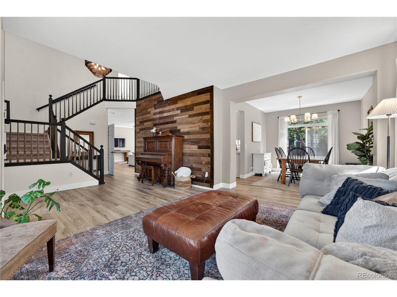 Experience the perfect blend of modern luxury, smart home technology, and entertainment excellence in Parker's coveted Willow Park community. This west-facing home is flooded with a ton of natural light and benefits from the afternoon sun for less snow shoveling. The exceptional curb appeal showcases professional landscaping, lush gardens, and a large mature tree. Step inside to high ceilings and a grand formal living room accented by a stylish wood feature wall and stunning bay windows that lead into a formal dining space. The heart of the home is the open great room featuring an updated kitchen. The gourmet kitchen boasts premium quartz countertops, chic white cabinetry, a central island with a breakfast bar, a built-in desk, and a dining nook. Sliding glass doors off the dining nook offer great indoor-outdoor living, and the family room's gas fireplace is perfect for chilly Colorado evenings. The main floor features an upgraded mudroom leading to the oversized, attached three-car garage. The original main-floor laundry hookups and venting remain completely intact behind the walls for easy conversion back, if desired. Upstairs are four spacious bedrooms on one level, including a primary suite with vaulted ceilings, an updated five-piece en-suite bath, and a walk-in closet with a laundry area. The finished basement is an entertainer's dream, hosting a surround-sound home theater with premium speakers and a professional multi-room recording studio. This studio features a hidden egress window behind a panel, allowing for an easy bedroom conversion. The utility space holds a 50-gallon water heater (2021) and a furnace (2022, same as the AC). The fully fenced, park-like backyard is a shaded oasis with mature trees. Smart systems include light switches, security cameras that stay, thermostat, sprinklers, garage, lock, and appliances. Enjoy walking trails with mountain and sunset views, tennis courts, and a park, all only four minutes to Main Street Parker!