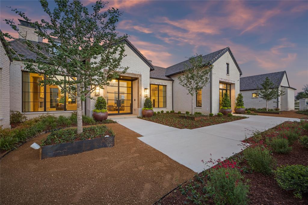 Perched atop a scenic hill in Fort Worth’s prestigious Montrachet neighborhood, this stunning single-story residence draws inspiration from the rustic elegance of Napa Valley. Designed to capture panoramic views of downtown Fort Worth, the home seamlessly blends refined architectural elements with natural textures and warm, vineyard-inspired tones.

Spanning a thoughtfully designed layout, the home features 4 bedrooms, 4 full and 2 half bathrooms, and a 3-car garage with additional motor court parking. The primary suite offers a true retreat with its own private patio, sitting area, dual closets, a safe room, separate vanities, a freestanding tub and walk-in shower, coffee bar, and a connected laundry room. Each of the three additional bedrooms includes ensuite baths and custom walk-in closets.

Designed for effortless living and entertaining, the open-concept living room flows into the dining area and chef’s kitchen—complete with a central island, a spacious back kitchen, and a separate walk-in pantry. The great room features a stylish wet bar, while a dedicated study offers a quiet space to work or unwind. A separate lounge with its own wet bar opens directly to the back patio, creating seamless indoor-outdoor living.

Outside, the amenities continue with a fully equipped outdoor kitchen, covered living area, and a sparkling pool—all framed by sweeping skyline views.

Architectural details include rustic stonework and distressed wood accents with a modern twist. The home’s clean exterior lines, metal accents, and limewashed finishes lend a timeless character, while the interior embraces soft greens, earth tones, and vineyard-themed color palettes—chardonnay, merlot, and cognac—infusing every space with a sense of warmth and lived-in luxury.