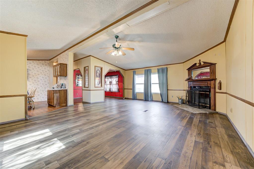 Welcome home to this 2 acre wooded property with a spacious and well-maintained home offering over 1,700 sq. ft. of comfortable living space! This charming 3-bedroom, 2-bath home features a warm and inviting living room with a wood-burning fireplace, perfect for cozy evenings. The wood-look laminate floors in the living, formal dining, and hallway areas add durability and style throughout.The functional kitchen features tiled-edge countertops with striking emerald-green tops, a gas stove, dishwasher, and one year old refrigerator that stays! Just off the kitchen, you’ll find a utility room with washer and dryer included, leading conveniently out to the backyard.Enjoy comfort year-round with Central HVAC, routinely serviced by Air Comfort Solutions, and replacement vinyl windows that enhance energy efficiency. The spacious primary suite offers a huge walk-in closet, double vanity, soaker tub, and a recently updated walk-in shower (only one year old).  Lastly, find two large guest bedrooms with plenty of closet space.Outside, you’ll appreciate the large back porch, two outbuildings for storage, an in-ground storm shelter, and a fully fenced yard. The home is served by well and septic, both recently serviced, with a new pressure tank in the well house.This property has so much to offer—peaceful country living with all the modern comforts already in place! Don’t miss the chance to make this wonderful home yours!