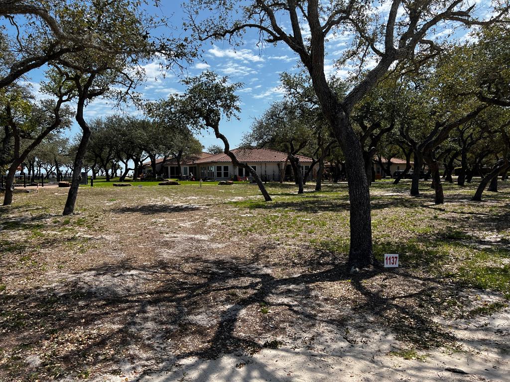 Ready for days of bay views and evenings of gentle breezes? Call Royal Oaks your home and you will everyday. This 6032 sq.ft. lot provides beautiful water views of Aransas Bay and is only limited by one's imagination. Royal Oaks is wrapped in luxury from the start. From the cobble stone road leading to the guard house and through the gates, you find tranquility from beginning to end. Each lot provides ample space to design the perfect custom home surrounded by iconic windswept Oak trees. Never take for granted the pleasure of privacy this neighborhood provides and all the amenities it has to offer. Catch up with friends and neighbors around the tastefully designed gazebo and fire pit overlooking the bay while practicing your putting skills on the green. If you love fishing, take time on the private lighted fishing pier. Texas sunrises over the bay are priceless but you can afford to have it at Royal Oaks. Call today for a personal tour!