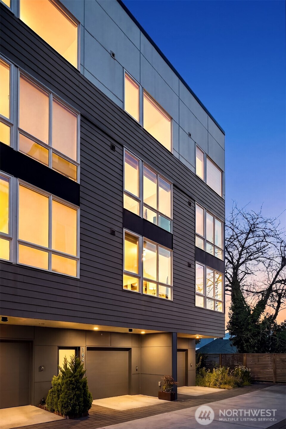 Experience the pinnacle of Capitol Hill living in this exceptional, lightly lived-in 2019 contemporary townhome. Better than new and meticulously upgraded throughout, this property shines with fresh interior paint, custom designer lighting, and premium finishes. The main level boasts an open layout with tall ceilings and expansive windows, bathing the space in natural light. Culinary enthusiasts will love the chef’s kitchen, featuring a custom island, sleek cabinetry, quartz countertops, and high-end appliances designed for effortless hosting and everyday meal prep. The thoughtful floor plan offers excellent privacy. One level up, find a welcoming guest room with a chic bath and a dedicated office nook that provides the ideal work-from-home setup. Above, the exclusive top-floor primary suite serves as a true sanctuary, complete with a massive bathroom and a luxurious walk-in shower. Escape to the rooftop deck to take in sweeping views of the downtown Seattle skyline and Mount Rainier—an incredible backdrop for relaxing or entertaining. Additionally, an attached one-car garage offers highly coveted secure parking and extra storage. Situated in one of Seattle's most walkable and vibrant neighborhoods, you are mere steps away from diverse local cafes, acclaimed restaurants, lush parks, boutique shopping, and minutes to DT, SLU, I-5/I-90 and light rail. Turnkey luxury, prime location, and modern design come together in perfect harmony.