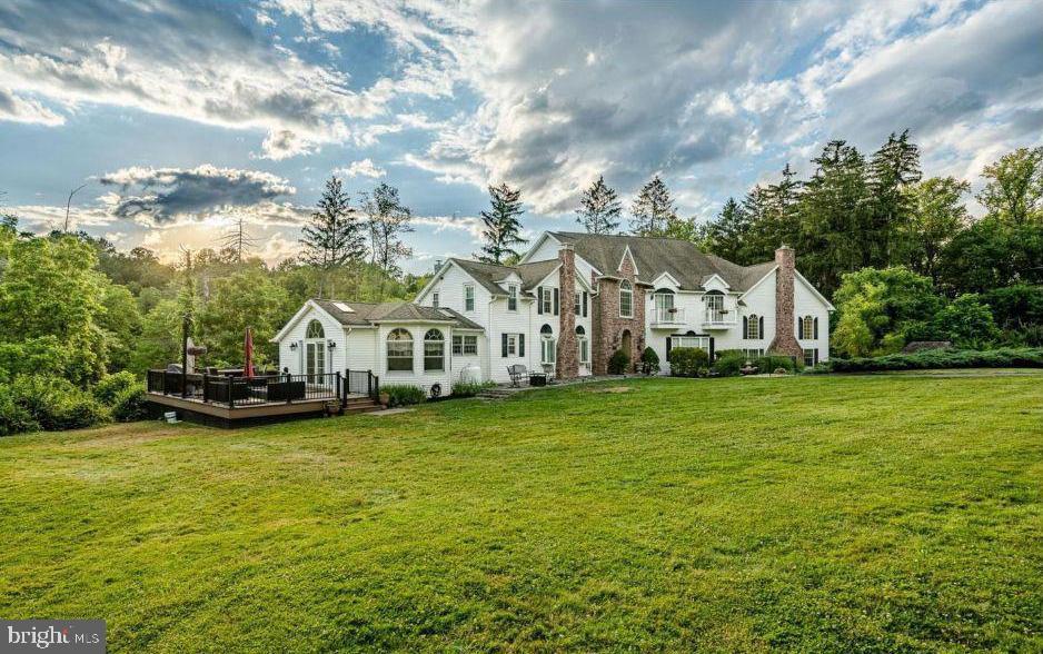 Set along a picturesque, tree-lined driveway, this extensively renovated estate offers a seamless blend of timeless character and modern sophistication. Featuring 6 bedrooms and 4.5 baths, the home is privately situated on nearly 24 breathtaking acres of rolling pastures and tranquil woodlands—providing exceptional seclusion with no HOA and no risk of nearby development encroaching on your space.A collection of versatile outbuildings—including a barn and a charming cottage—enhances the property’s appeal, making it ideally suited for equestrian pursuits, hobby farming, multigenerational living, or potential income opportunities such as long- or short-term rentals.Inside, a refined yet highly adaptable layout unfolds, thoughtfully designed to evolve with your lifestyle—offering comfort and functionality through every stage of life. Whether accommodating remote work, multigenerational living, or changing day-to-day needs, the home’s flexible design allows spaces to be reimagined with ease while still providing an elegant setting for both everyday living and entertaining.The formal living room exudes warmth with exposed beams, gleaming hardwood floors, and a striking stone fireplace with mantel, while a generously sized dining room creates a sophisticated backdrop for gatherings. At the heart of the home, the updated eat-in kitchen features high-end appliances, quartz countertops, a large center island, ceramic tile flooring, custom cabinetry, a pantry, and a beautifully hand-painted ceiling. Large windows, skylights, and sliding doors fill the home with natural light throughout.The main level offers exceptional versatility, with spaces that can easily shift to meet your needs—featuring a private office, powder room, dedicated theater room, an additional spacious office or flex room, a butler’s kitchen, and a stunning two-story great room. This standout space showcases Brazilian cherry hardwood floors, a dramatic floor-to-ceiling stone fireplace, and expansive windows and French doors that open to multiple porches and decks, creating a seamless indoor-outdoor lifestyle.Upstairs, generously sized bedrooms provide comfort and privacy, anchored by the luxurious owner’s suite. This serene retreat includes a spacious bedroom, an atrium-style sitting area with balcony access overlooking the picturesque grounds, and a spa-inspired bath complete with a double-sided gas fireplace.The finished basement further enhances the home’s adaptability, offering flexible space ideal for recreation, fitness, guest quarters, or entertaining, along with an unfinished area that provides ample storage.Outdoors, the property truly shines with boundless potential. Multiple porches and decks offer peaceful vantage points to enjoy the surrounding landscape, while a separate two-story structure with a two-car garage, livestock stalls, and an unfinished loft provides additional flexibility for a variety of uses.With its rare combination of natural beauty, refined living spaces, and exceptional versatility, this remarkable estate presents a truly one-of-a-kind opportunity.