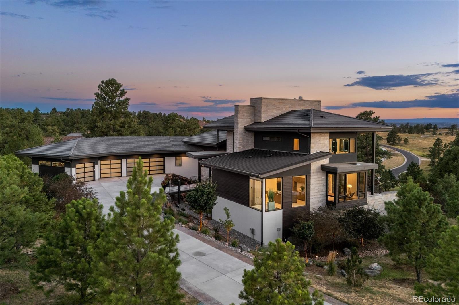 Named Denver Life Magazine’s 2021 Designer Showhouse, this residence is as refined as it is remarkable. A rare mountain-view 5 bed | 6 bath 2+ acre estate located in the coveted, gated Colorado Golf Club community, this home is perfectly poised to offer mile high living at its finest on one of the neighborhood's most desirable lots.  At its heart, the great room boasts a gas fireplace with a striking floor-to-ceiling stone | tile statement wall and 10-foot, 5-panel sliding doors opening to an enormous deck with sweeping Front Range views. The elevated kitchen features professional-grade appliances, quartz and soapstone accents, and a back kitchen worthy of a chef. Framed within a gorgeous vista, the primary suite offers a spa-inspired bathroom, glass-faced shower, unique dual vanities, and a sizeable closet. Grounded by an excellent open flow, the main level continues with an inviting dining room, sunlit office, laundry room, powder room, & anomalous main level guest bedroom with en suite bath. Upstairs, a private suite perched above the trees is one that your guests won't want to leave. The walk-out lower level impresses with a stylish rec room, family room, climate-controlled wine room, gym, 2 additional bedrooms with en suite baths, and ample unfinished storage. Outdoors, the serene setting unfolds like a nature preserve with manicured landscaping, expansive patios, and a large deck - creating multiple venues for relaxation and entertaining. A true oasis, every amenity has been considered from a top-tier Savant whole-home audio system to a 6+ car garage. Unmatched, the community offers world-class golf and miles of private trails. To put it simply, impactful living opportunities like this are exceedingly rare and almost impossible to replicate—an award-winning estate exceptionally positioned among soaring pine trees that embodies elegance, privacy, and peacefulness while showcasing extraordinary architecture, modern design, and impeccable finishes.