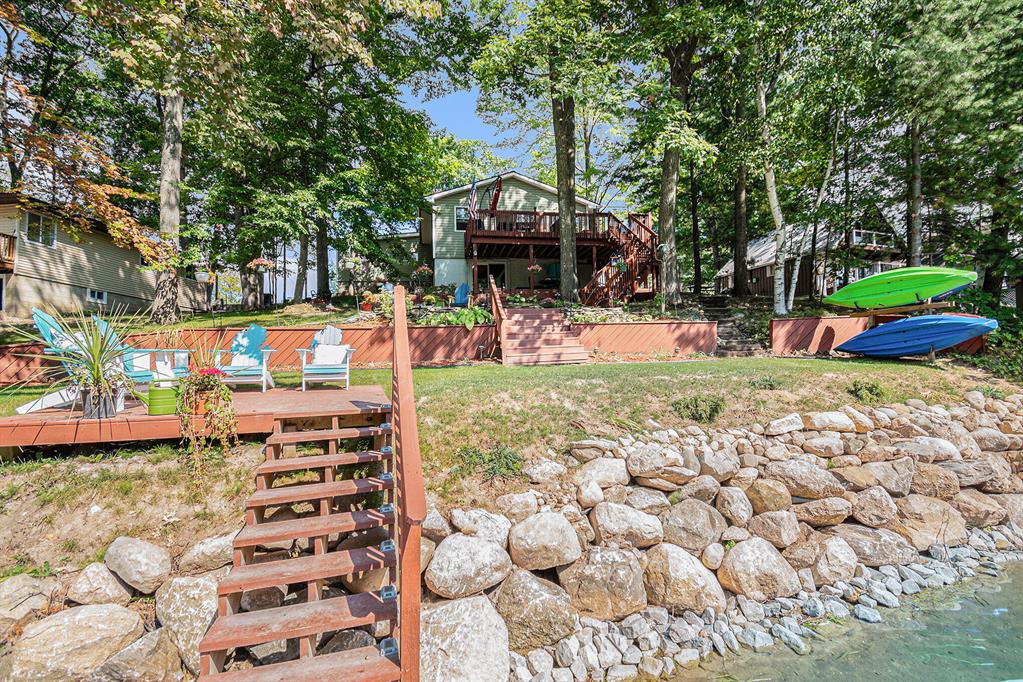 Welcome to your Five Lakes waterfront retreat! This inviting 3-bedroom, 2-bath home with full finished basement that nearly doubles your living space is just minutes from historic downtown Clare. Beautiful tiered landscaping and gradual steps to the lake include an EGLE-approved shoreline, paver walkways, lakefront deck, aluminum dock, and motorized boat lift. Inside, the home has been thoughtfully updated over the past four years with a new roof, added second bath, remodeled upstairs bath, updated flooring, fresh paint, appliances, kitchen counters and backsplash, replaced sliding door in the walkout basement, water heater, water softener, reverse osmosis system, new drywall ceilings, updated fixtures, and epoxy garage floors. The layout features main floor laundry and a finished walkout basement with family room and storage. Oversized 3-4 car garage offers space for hobbies and lake toys. Just seconds from the deepest part of Five Lakes--move in and start enjoying lake life