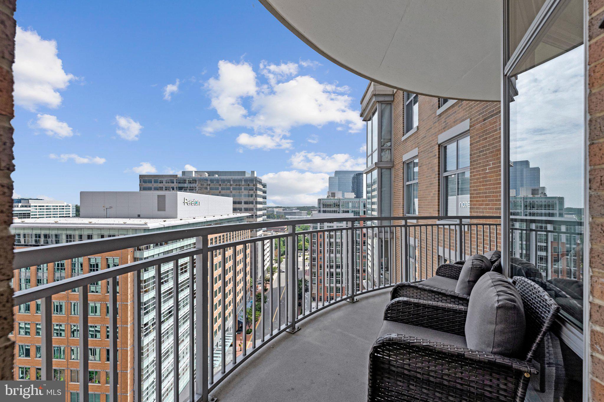 Luxury Living Above Reston Town Center! Perched on the 15th floor of Midtown, Reston Town Center's only high-rise condominium, this stunning residence combines sophisticated finishes, dramatic panoramic views and an unbeatable walkable lifestyle. Expansive open spaces, floor-to-ceiling windows and soaring 10-foot ceilings (which only two residences with this floor plan feature) create an exceptional sense of light and space. Enjoy beautiful southern skyline views, including vibrant fall colors and a front-row seat to the annual Reston Holiday Parade. The gourmet kitchen features granite countertops, stainless steel appliances and 42-inch cabinetry. Gorgeous hardwood floors extend throughout the unit. Thoughtful upgrades include remote-controlled motorized shades on every window including blackout shades in both bedrooms. The open living area features triple floor-to-ceiling windows and two glass doors leading to the expansive, curved private balcony, with an additional door from the second bedroom. It's the perfect spot for morning coffee, entertaining or unwinding with a glass of wine while overlooking the energy of Reston Town Center. A spacious, flexible room near the entry can serve as a dining room, home office, den or whatever fits your lifestyle. The luxurious primary suite offers a customized walk-in closet with built-ins and a spa-like en-suite bath featuring a granite double vanity, separate shower, soaking tub and private commode area. The second bedroom includes a walk-in closet, access to a second full bath and its own balcony access. Deeded garage parking space conveys.Midtown residents enjoy an impressive array of five-star amenities, including 24/7 concierge, resort-style pool and hot tub, state-of-the-art fitness center, private screening room, game room, catering kitchen, party room, conference room, two terraces with gas grills, and two guest suites for visiting guests. On-site management and resident activities such as book club, movie nights, and social events add to the exceptional lifestyle.Best of all, everything is right outside your door. Walk downstairs to Ruth's Chris Steak House in the Midtown building or stroll to Reston Town Center's renowned restaurants, shopping, entertainment, movie theater, summer concerts, winter ice skating and arts scene. The W&OD Trail and Reston Town Center Metro station are also just steps away. This is luxury, convenience and vibrant urban living at its best in one of Northern Virginia's most coveted locations.