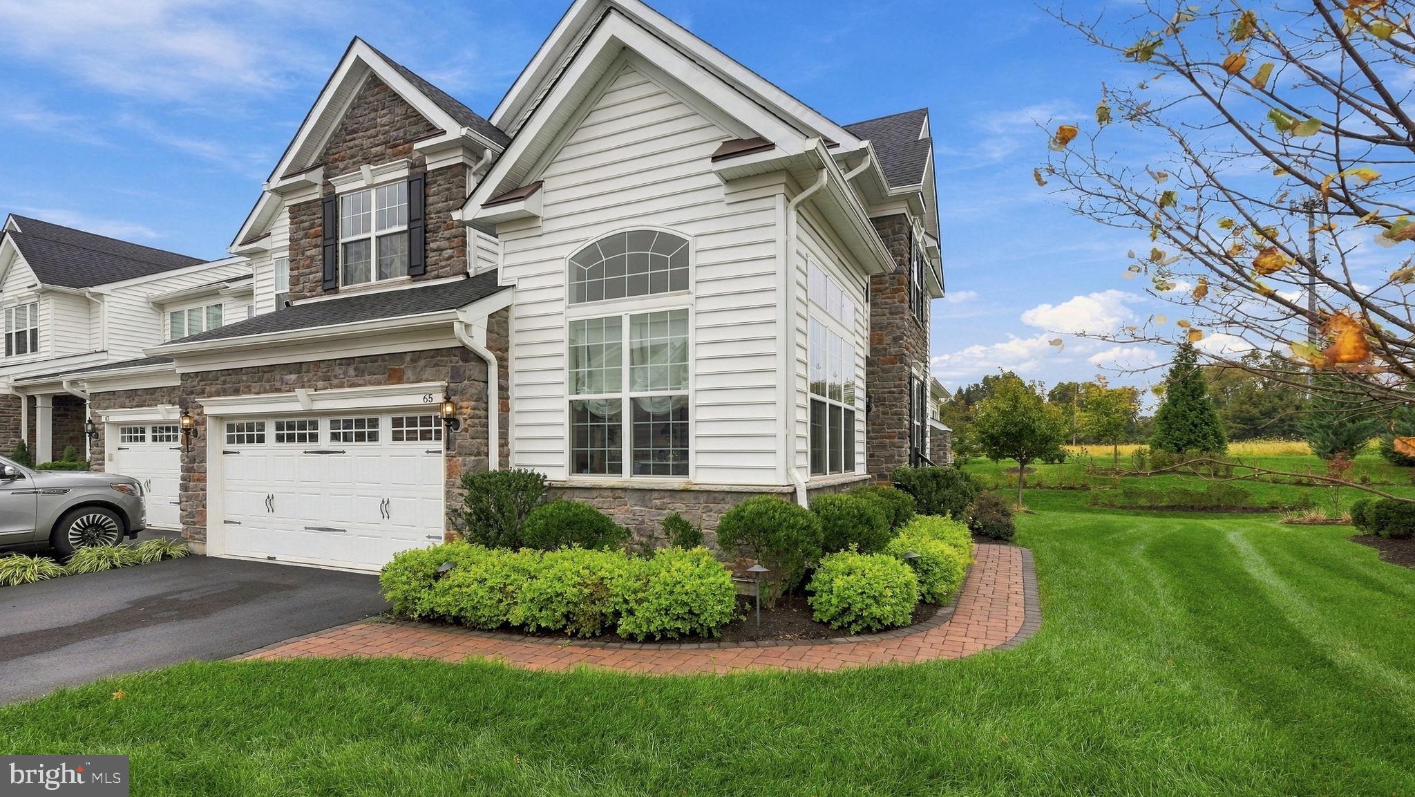 Welcome to 65 Lavender Drive. This 3BR/4bath Townhouse located at Regency At Yardley Carriages (by Toll Brothers) is in the heart of Historic Bucks County. This bright and stunning END UNIT townhouse has “The Bucknell ” floor plan with upgraded recessed lighting, bathrooms, wood floors, carpeting, a custom gourmet Wolf/SubZero kitchen and many, many more upgrades. The main level is designed for ease of living with a semi open layout that includes an amazing two story ceilings in the Foyer and Dining Room. Nine foot ceilings throughout with vaulted ceilings in LR & Family Room along with a tray ceiling in the primary first floor en-suite bedroom.The custom kitchen is a show stopper that features a walk in pantry, granite countertop, marble tile backsplash, soft light wooden cabinets, high end appliances, and an inviting large, double sided storage island housing a drawer microwave and breakfast bar. A cozy vaulted family room sits directly off the kitchen with a gas fireplace and patio doors that open to a TREX deck. Step out to the roomy deck, furnished with a remote retractable awning, for a quiet cup of morning coffee or evening grilling that looks out onto open space and trees. A finished attached 2 car garage, with epoxy coated non slip flooring, is accessed off the laundry room and a half bath complete the main level. A custom staircase leads you up to a huge second floor loft area, with two additional bedrooms with walk in closets connected by a Jack and Jill bathroom.Fully carpeted stairs take you downstairs to a large finished basement that has luxury vinyl flooring, private storage areas, a half bath and a patio door that opens onto a custom stairway egress which allows you to access the back yard and deck area.Discover this jewel of a townhouse at Regency at Yardley Carriages, a gated and highly sought-after 55+ community, built in 2021. Life in Yardley is difficult to beat, classic small-town charm surrounded with everyday convenience. You are close to shops, cafés, parks, and the riverfront, plus nearby trains and major freeway I95 & Turnpike routes along with Septa that make commuting( NY & Philly) and day trips straightforward. Community amenities include indoor/outdoor swimming pools, tennis/pickleball courts, bocci, fitness center, saunas, whirlpool and a clubhouse with pool tables, card tables, table shuffle board and many other activities of interest to join. Landscaping, snow and trash removal add comfort and low-maintenance living to the mix. This is a practical and very well appointed home in a prestigious community location.