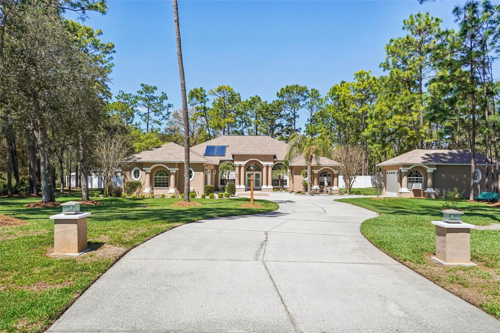 Meticulously maintaned executive home offers an impressive combination of modern upgrades, energy efficiency, and exceptional outdoor living all situated on a spacious one-acre lot with no HOA or CDD fees. With extensive improvements throughout, the property features a new roof (2025), fresh exterior paint, and a solar hot water system for added efficiency. The home includes an attached oversized 3-car garage as well as a detached 1.5-car garage, with the detached garage insulated and equipped with a window A/C unit, commercial fan, and upgraded lighting. Additional exterior enhancements include gutters, landscape curbing, well for irrigation, and a backup generator. The backyard is designed for relaxation and entertaining, featuring a 14 x 24 pool with a salt chlorination system, new tile, recessed lighting with fans, along with two 12x16 aluminum sheds with roll-up doors. Inside, the home has been thoughtfully updated with all new appliances, new tile flooring, new vinyl flooring in the primary bedroom. Both bathrooms feature granite countertops and double sink vanities, and the primary suite includes a large jetted tub and a spacious shower with three shower heads. Additional interior upgrades include custom oak built-ins in the living room and office, powered shades, all new blinds and Levolor window coverings, a whole-house music system extending to the lanai, a mini-split AC system in the primary bedroom making this a move-in ready home with exceptional features and long-term value.