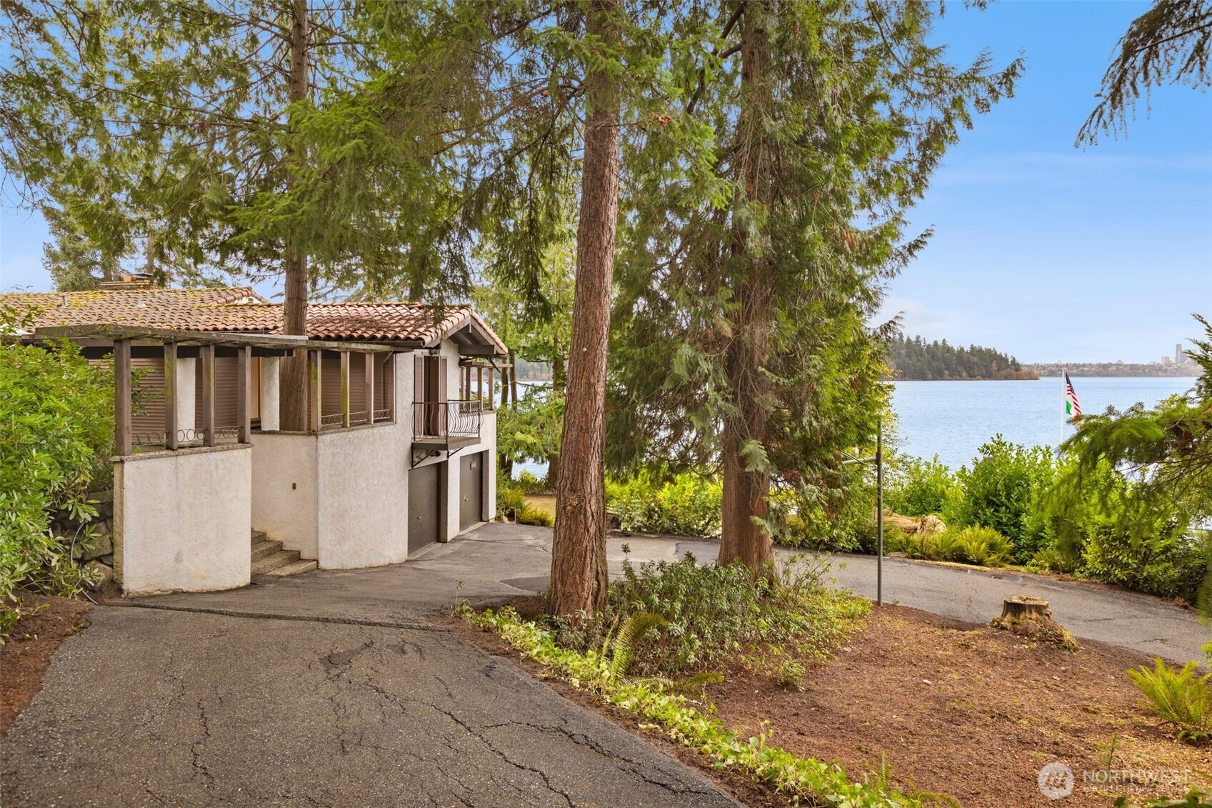 A rare west-facing Mercer Island waterfront legacy, this extraordinary offering presents a once in a generation opportunity to create an iconic estate. Set on approximately 28,000 square feet of private, forested grounds with 150 feet of shoreline, the property commands sweeping views of Seattle’s skyline, Seward Park, glowing sunsets, and the dynamic beauty of Lake Washington. The setting feels tranquil and secluded, yet remains moments from the heart of Mercer Island and within effortless reach of Seattle, Bellevue, Issaquah, and year round mountain recreation. A private dock supports an exceptional lakeside lifestyle with boating, swimming, paddleboarding, and long summer days on the water. The existing 3880 sq foot residence is rich in timeless character and presents an ideal candidate for a comprehensive gut renovation, preserving its soul while elevating it to modern luxury standards, or alternatively offers a compelling canvas for new construction that fully maximizes the premier west side waterfront setting. Located in one of Mercer Island’s most coveted neighborhoods, this rare property benefits from top rated schools, a strong community, and enduring long term value through irreplaceable land and views.