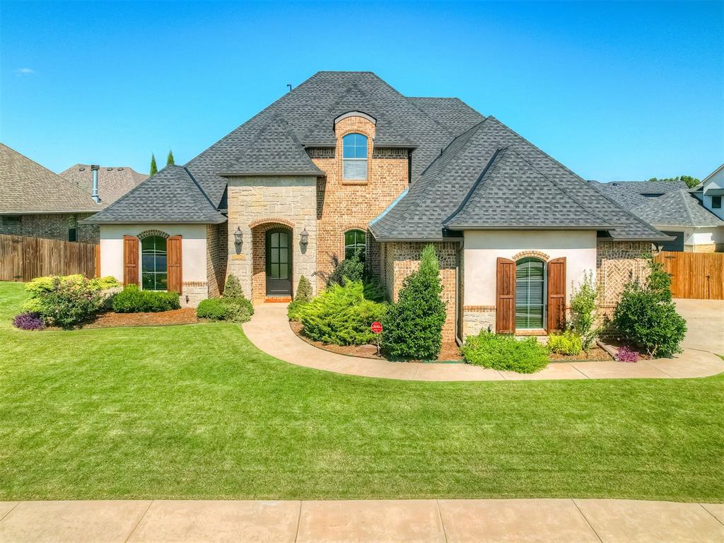Welcome to your dream home in the gated community of The Lakes at Traditions! This stunning 4-bed, 3.5-bath home offers 3,242 sq ft of beautifully designed living space, complete with a 3-car garage and situated on a desirable corner lot. Step inside to find gorgeous hand-scraped wood floors in the entry, formal dining, and main living area. The huge living room features a striking stone fireplace and giant windows that bring in abundant natural light and offer peaceful views of the backyard—giving you the feeling of being outdoors from the comfort of inside. The chef’s kitchen is a true highlight, featuring a center island, gas range, double ovens, bar seating, ample cabinetry, a large corner pantry, and an eat-in dining space that’s perfect for everyday meals or entertaining.  The formal dining room provides the perfect setting for holiday gatherings and family get-togethers. The oversized primary suite is a private retreat with a luxurious en-suite bath, including dual vanities, a soaking tub, a huge walk-in shower, and a spacious walk-in closet. A second bedroom with a private en-suite bath is conveniently located on the main level—ideal for guests or multigenerational living. The dedicated study is an elegant and inspiring space, featuring rich wainscoting and a raised paneled ceiling.  Upstairs, you'll find two more bedrooms that share a Jack & Jill style bathroom, along with a large bonus room—perfect for a theater, game room, etc.  Outdoor living is a breeze with a newly extended back patio featuring a built-in gas grill—perfect for hosting or relaxing in your private backyard.  This home features all new paint, carpet, and a brand-new roof!  Enjoy all the savings of Oklahoma City utilities, and benefit from the ideal location just minutes from the Kilpatrick Turnpike and Broadway Extension, offering quick access to anywhere in the metro.  Don’t miss your chance to own in one of South Edmond’s premier gated neighborhoods. Schedule your private showing today!