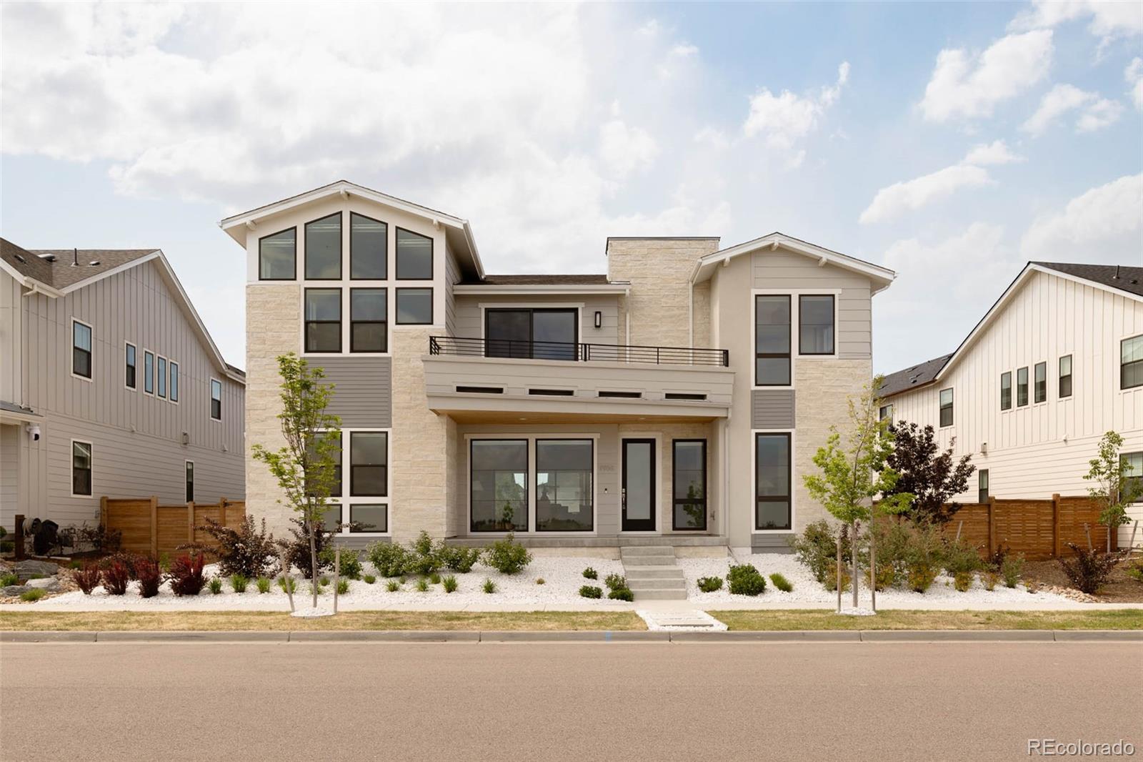 Infinity Luxe residence blends modern architecture, craftsmanship & unobstructed Rocky Mountain Wildlife Refuge views into a rare offering. Contemporary white rock landscaping & striking curb appeal set the tone, while soaring ceilings, expansive windows, engineered hardwood floors, designer LED lighting & integrated smart-home technology create an elevated living experience throughout. A glass-enclosed office filled with natural light is off the entry. Nearby, a Taj Mahal quartzite powder room showcases designer finishes. The great room is anchored by a Neolith tile fireplace & framed by walls of glass overlooking the refuge, with automatic blinds & built-in surround sound enhancing the space. Push back the stacked slider to invite the outdoors in and enjoy the covered patio that leads to the spacious yard. At the center of the home, the chef’s kitchen features a leathered quartzite waterfall island, custom cabinetry, walk-in pantry & a full Wolf & Sub-Zero appliance suite including a built-in espresso maker, induction oven, steamer & oversized refrigeration. The dining area flows seamlessly for entertaining. A main-level guest suite with a spacious closet & ensuite bath. Upstairs, a sprawling loft opens to a private balcony w/ stunning views. The primary suite captures mountain vistas & features a custom walk-in closet w/ floor-to-ceiling built-ins, center island & dedicated shoe wall. The spa-inspired bath includes an oversized glass shower & soaking tub. Additional upper-level bedrooms offer ensuite or Jack-&-Jill baths, while an additional covered balcony w/ a warm wood-plank ceiling creates a private outdoor retreat for relaxing and entertaining. An oversized laundry room with abundant storage adds everyday convenience to the upper level. The finished basement includes a cinema space with projector & screen, dedicated gym, recreation space, additional bedroom suite, Control4 automation, whole-home humidification, pre-wired routers & 18+ built-in speakers.