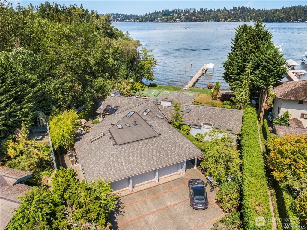 The epitome of waterfront living on Mercer Island's tranquil north shore. This rare rambler-style beach house offers a serene retreat with 4 bedrooms, including a primary suite boasting stunning views & 5-piece bath. The 85ft of private low-bank waterfront & sandy beach provide the perfect escape. Luther Burbank Park borders the west side, enhancing the natural beauty of the surroundings. Private dock w/covered boat & jet ski lifts offer unparalleled convenience. Spacious backyard features a large deck,Viking grill, sportcourt, hot tub, and panoramic views of Mt. Rainier & the Eastside. With an attached 3-car garage, this home seamlessly combines luxury with practicality. Newly refinished hardwood floors.