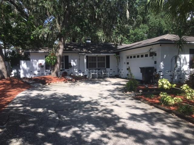 NO HOA! Must see this 3 BR 2 BA single family residence in Brandon, FL with attached 2-car garage! This solid concrete block construction home features a split bedroom plan, laminate floors in bedrooms and tile floors throughout the main areas. The spacious open-concept kitchen, living, and dining room arrangement creates a welcoming flow, highlighted by a beautiful wood-burning fireplace and a large window that fills the space with natural light. The west-facing property provides warm, golden light and beautiful sunset views, while its location on a quiet street offers safety and peace of mind. A small garden in the front yard adds charming curb appeal, complemented by a stunning mature palm tree that enhances the property’s character. Step outside to enjoy the beautiful outdoor lounge area on the open patio, complete with chain link fencing and rolled bamboo privacy panels, all overlooking a lush backyard filled with palm trees, vibrant plants, and greenery. A screened patio adds even more space for relaxing or entertaining.  All appliances, including washer and dryer, are included, making this home truly move-in ready. With short-term leases allowed, it’s a fantastic investment opportunity as well as a personal residence. Seller financing available. Do not wait, it will not last long!