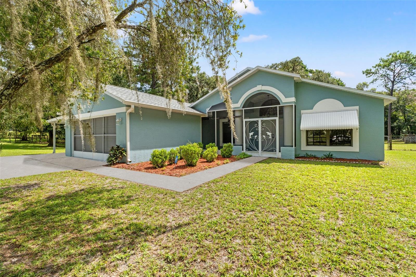 Looking for acreage paired with an adorable, well-maintained home? Look no further! Nestled among mature shade trees in one of Hernando County's most sought-after and peaceful neighborhoods, this charming 3-bedroom, 2-bathroom home sits on 2 fully fenced acres in the heart of Brooksville. Enjoy the peace of mind that comes with major updates already completed, including-- Roof (2019), AC (2020), Water heater (2020) and updated septic system and drain field (2023). As you arrive, you'll be greeted by scenic views and a sense of serenity. The oversized driveway leads the way to the spacious screened-in front porch, welcoming you into the home through double doors, where you'll find soaring cathedral ceilings and abundant natural light throughout. The open floor plan features newer tile flooring, creating a fresh, modern feel. The owner's suite is thoughtfully located on one side of the home for added privacy and includes two oversized walk-in closets, a spacious ensuite bathroom, and direct access to the lanai. On the opposite side of the home, ideal for privacy, you will find two generously sized guest bedrooms, both with ample closet space and large windows. The updated guest bathroom (2024) includes a brand-new vanity, tiled shower, and flooring. In the back of the home is an oversized Florida room, a perfect place to create an office, playroom or gym. This massive space opens to the real showstopper! The backyard oasis. This gorgeous, expansive lot offers endless opportunities for outdoor enjoyment—whether it's a creating a garden, watching nature or enjoying Florida this serene space has it all!  An oversized storage shed with electricity and 2 chicken coops to bring country living to life, as well as a fire pit! Zoned Residential Agricultural, to enjoy livestock and opportunities with the land! Some other great features, there is an additional carport, a freshly painted garage floor, and hurricane shutters. With being less than 10 minutes from downtown, and close to I-75, you are surrounded by everything you could desire! This rare gem won't last long. Schedule your private showing today and make this peaceful retreat your new home!