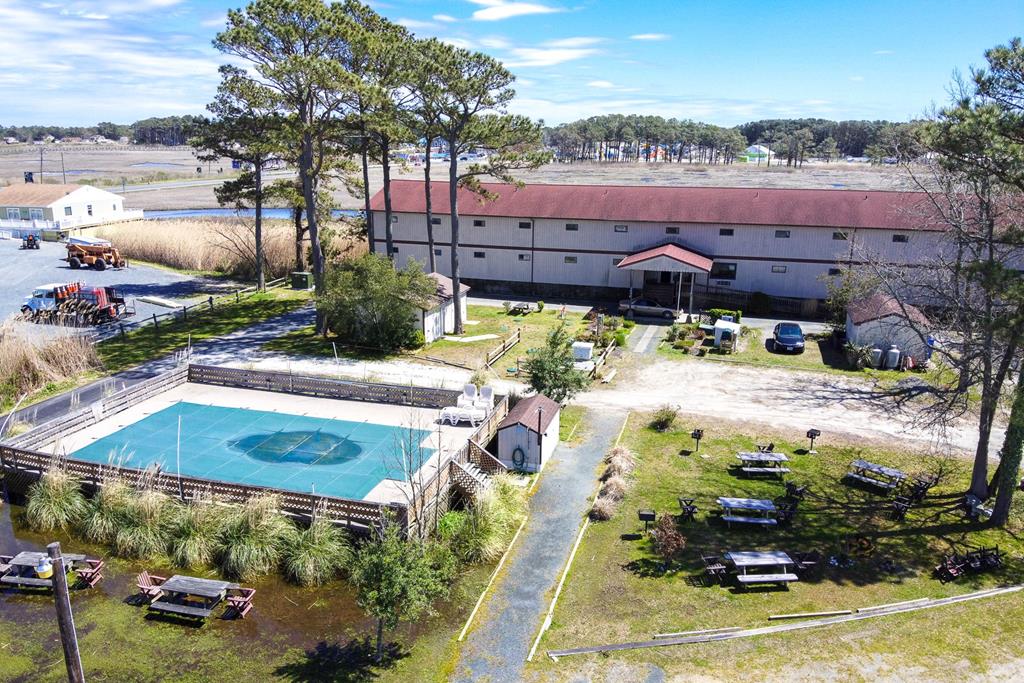 This renovated 2-bedroom, 2-bath waterfront double efficiency unit at Assateague Inn offers a unique combination of two connected units, providing privacy and convenience. Each unit features a shared kitchenette with a modern tile backsplash and microwave, plus sleek LVP flooring throughout. The main area includes a vanity sink and full bathroom, while the second unit offers a spacious bedroom with private outside access. Separate heating and A/C systems ensure personalized climate control. Enjoy waterfront views, a dock, an outdoor pool, and easy access to nearby shops, dining, nature, and beaches.
