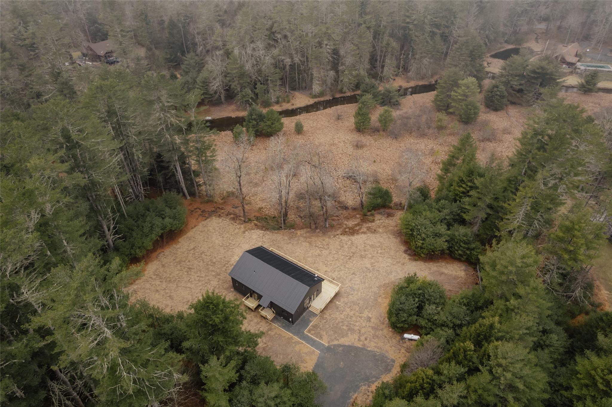 Birds eye view of property with a wooded view