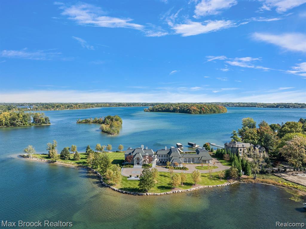 Discover a once-in-a-lifetime opportunity to own a stunning luxury estate on a rare and beautiful peninsula, with sunrise and sunset views overlooking Orchard Lake. This property is now available for the most discerning buyer seeking unparalleled elegance and tranquility. This architectural masterpiece, built by Thomas Sebold & Associates, and designed by Carrie Long Interiors, flawlessly blends with its breathtaking surroundings, inviting you to explore a variety of exquisite living spaces. Featuring gorgeous lake views from nearly every room, this meticulously renovated 2.5 acre parcel is situated behind a private gate in an exclusive community of lakefront properties. The home offers jaw-dropping vistas of Orchard Lake at every turn. An impressive list of amenities awaits, perfect for entertaining friends and family. Highlights include a chef's kitchen with a walk-in pantry, multiple entertaining areas with the warmth of numerous  fireplaces, and thoughtfully designed spaces that maximize the stunning views. The primary suite boasts separate bathrooms and closets, a sitting room with a fireplace, and a workout room. The main living areas connect to outdoor dining and seating spaces, including a glistening swimming pool that overlooks the lake. The lower yard features a private sandy beach and a firepit area for gatherings by the lake. A private guest suite at one end of the home adds to the appeal, complete with a sitting room, dining area, and wet bar. No detail has been overlooked in this exquisitely designed home. This property is truly the ultimate in luxury living.