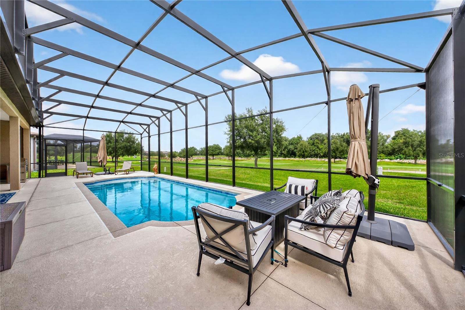 LOWER PRICE! ESCAPE TO YOUR OWN PRIVATE HOME PARADISE! Located in beautiful Del Webb Stone Creek! This Renown 2022 model has everything a luxury home gives. PRIVATE SWIMMING POOL WITH A SPECTACULAR GOLF COURSE VIEW, not to mention the rocky dry retention area beyond the golf course WOW! This spacious home checks all the boxes. Exterior has upgraded coach lights on timers, a premium glass insert on the front door with Wi-Fi keypad lock and professional landscaping. The exterior front home window has custom crown molding and shutters, giving it that special touch. The home opens up into a nice foyer entry, the dining, living room and open floor plan kitchen makes you feel right at home. Wood style ceramic tile in all living areas with luxury vinyl planking in bathrooms, NO CARPET.  A quiet newer dishwasher, composite sink with touchless faucet, soft close cabinet doors, roll out drawers and alluring quartz countertops with auto sensor lighting for the big pantry. Fans in every bedroom and family room. The home features a split floor plan with 2 bedroom guest suites for a total of 3.5 baths. Master bedroom provides two large walk in closets and doorway right into the laundry room, which can also be accessed from the garage open entry. Motion lights have been added in the laundry room, master bedroom and garage, never be in the dark. You will love programmable auto powered Levolor window blinds in the master bedroom, flex room, dining, cafe and family rooms. This home has rounded wall corners with a warm all home paint color. Enjoy the cleanest water with a whole home Eco-water filter and softener in addition to the reverse osmosis kitchen water filter. Walking through the sliding doors into your private pool area with giant birdcage and outdoor kitchen with grill and sink. The 12' x 30' pool is heated by electric and includes pool floor auto cleaner and auto fill technology for low maintenance. In the evening the view is even prettier with pool lighting and fans, all great for entertaining or just relaxing. The three car garage has plenty of room for vehicles, golf cart and storage, if that is not enough, there is already a garage storage rack in place, the garage floor has vinyl tiles and garage door is insulated. Irrigation and home thermostat is controlled with the newest wi-fi electronics that can be operated from your phone. This home has so many upgrades during the building and after. There is nothing for you to do but move in and relish everything that makes life easier. This is a golfers dream home or if you are looking for a private homesite with nothing to look at but green space, with woods and bolder rocks. This community offers many amenities, clubs, activities and has an on property restaurant. Golf carting is fun, go listen to music at the town square and have access to three shopping plaza's with doctors, additional places to eat, go to the dentist and visit three different grocery stores. You can even golf cart to the post office. There are NO homesites like this one! Come and enjoy your best life!