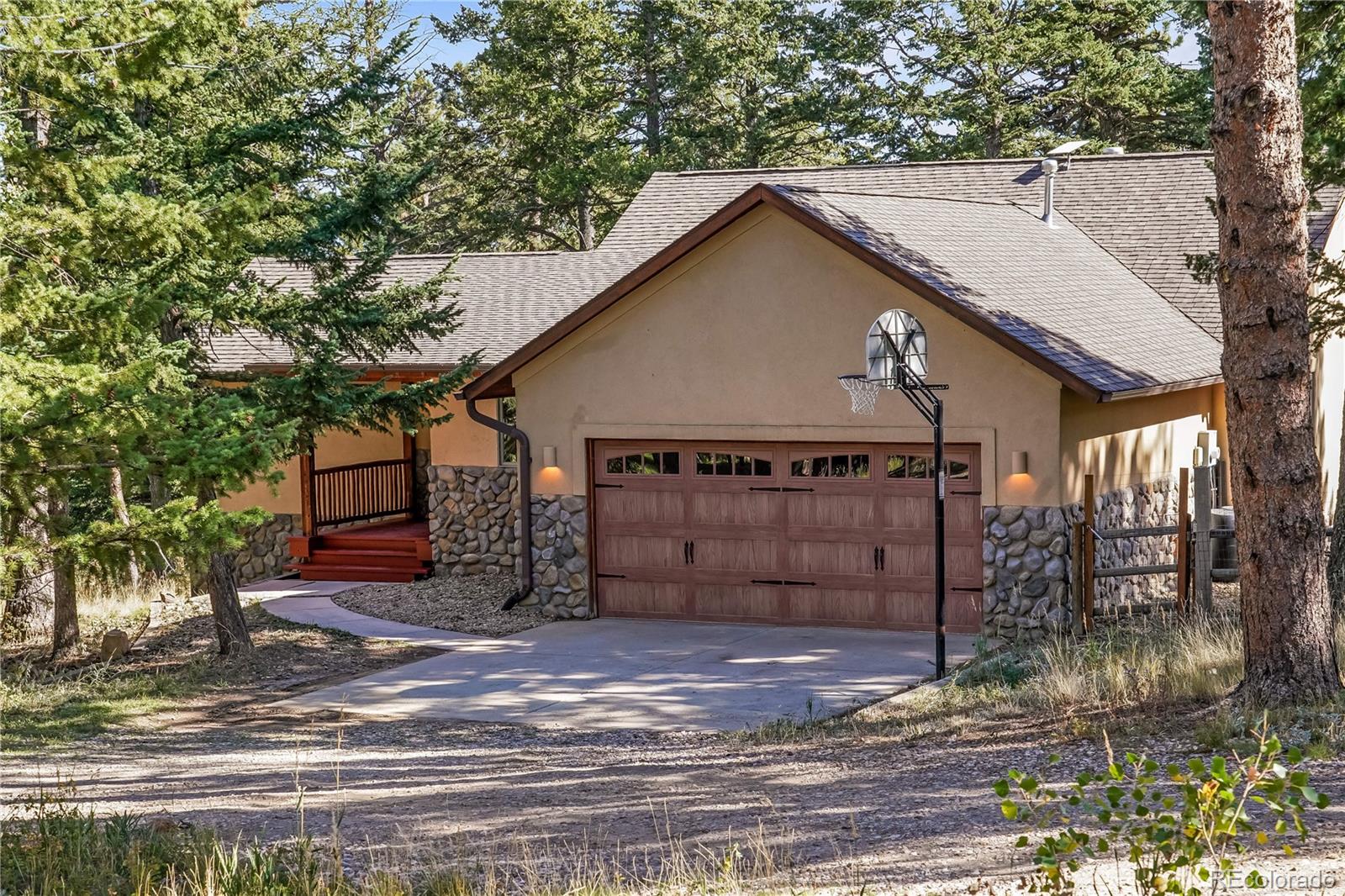 Set on 2.5 private, wooded acres midway between Nederland and Boulder, this 4-bedroom, 2,992-square-foot home offers true Colorado mountain living, with moose, elk, wild turkey, and owls as regular visitors. From the front, the home presents as a single-level ranch, but the sloped lot reveals a full walkout lower level with large windows bringing natural light into every room on both floors. A large wood deck on main level overlooks the forested acreage below, perfect for morning coffee and wildlife watching. Inside, the craftsmanship stands out: solid oak flooring throughout, with the main floor newly refinished; a layered lighting design with extensive recessed, under-cabinet, and cove lighting, a lit alcove, and lighted interior stairs; arched entryways; and extensive contemporary tile work, with corrugated metal accent walls adding a touch of mountain-modern character. The kitchen, updated with a new induction range, new dishwasher, and newer refrigerator, opens to the dining and living rooms. In the dining room, a built-in wet bar with a shimmering amber glass mosaic backsplash, lighted glass-front display cabinets, a solid-surface countertop, and a sculptural red sink makes entertaining elegant. Two of the four bedrooms are suites with private baths, one a 5-piece bath and the other a 3/4 bath with a large walk-in shower, ideal for long-term guests or extended stays. Upgrades include a new roof, new tankless water heaters, and a new Culligan water softener with whole-house filtration. The low-maintenance stucco exterior, with a stone facade wrapping the entire home, is built to handle mountain weather. Location is a highlight: about 20 minutes to Nederland's shops, restaurants, trailheads, and nearby Eldora skiing, and about 20 minutes to everything Boulder offers. Private, well-built, and move-in ready.