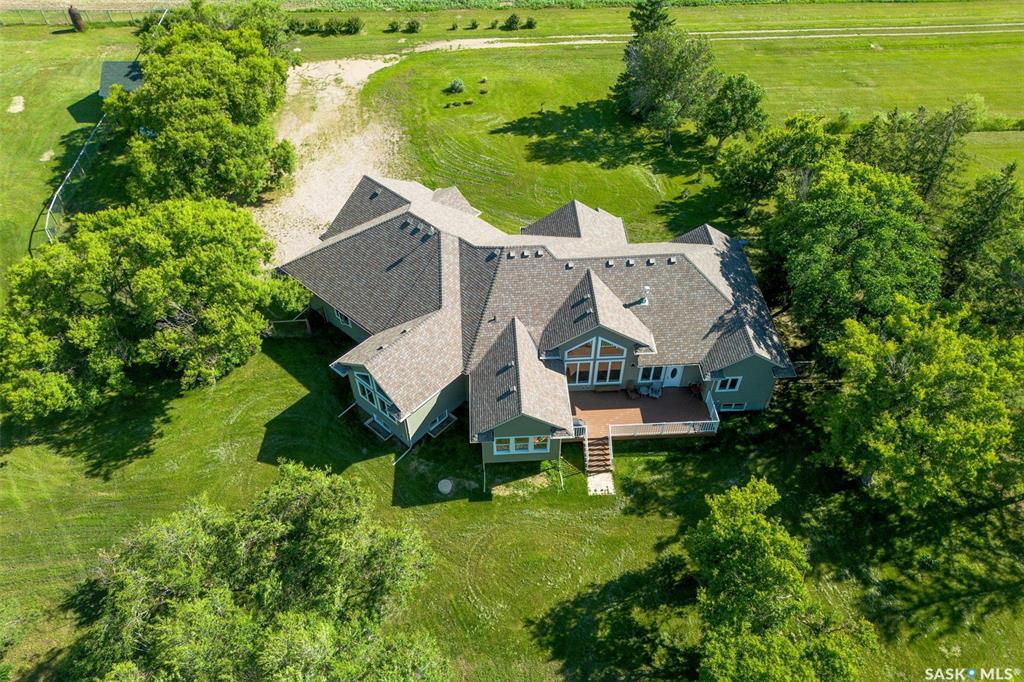Set just 22 minutes from Saskatoon and moments from Delisle, this beautifully developed 13-acre property offers the perfect balance of privacy, space, and accessibility.  Built in 2020, this custom bungalow delivers over 5,000 sq ft of finished living space with 5 bedrooms, 4 bathrooms, and a triple attached heated garage. Designed with both function and comfort in mind, the home features vaulted ceilings, expansive windows, and two propane fireplaces that anchor the main living areas.  The kitchen is built for everyday living and entertaining, complete with a large quartzite island, custom cabinetry, walk-in pantry, and JennAir appliances. It opens seamlessly to the main living space, creating a bright and welcoming central hub.  The primary suite offers a private retreat with a walk-in closet, spa-inspired ensuite, and direct access to the rear deck. A fully developed basement adds exceptional flexibility, featuring additional bedrooms, a full bathroom, and generous space for recreation, fitness, or a home office.  Outdoors, the property is exceptionally well-equipped with a heated and insulated shop, a 42’ x 70’ finished Quonset with concrete floor, and a horse stable—ideal for hobby use, storage, or business opportunities.  Constructed to a high standard, the home includes triple-pane windows, ICF foundation, ROXUL insulation, durable 50-year shingles, in-floor heating, high-efficiency mechanical systems, and a two-stage septic system.  Located just outside Delisle with quick access to Highway 7, this property offers a rare combination of modern construction, usable land, and versatile outbuildings in a highly desirable location. Detailed feature sheets are available for a complete overview of this exceptional home.