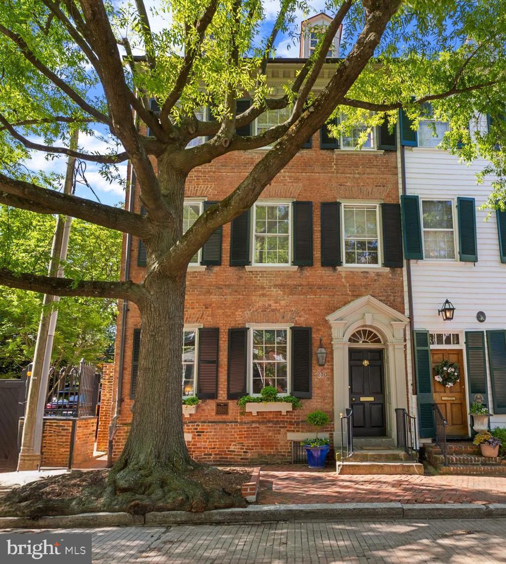 This 1784 residence located on Gentry Row in the heart of Old Town, Alexandria, is a TREASURE!   Exquisite details, custom built-ins, sought-after updates and overwhelming charm characterize every level of this all-brick home.  Classic federal architectural details, a recessed entrance, custom window planters and handsome shutters greet you on one of the sought-after and most famous streets of this historic seaport.     A lovely entrance hallway, approximately 6 feet wide and 20 feet long, is graced by a keystone window above the front door.  Its 10' ceilings are capped by period dentil molding, chair rail and custom faux paintine wallpaper both above and below the chair rail.  A period fixture is just one of many throughout this home.  Original floors throughout most of the residence, wide pine planks, are both warm and welcoming.     The stately living room is the first room to the left of the entrance hall and offers 2 deep windows sills with tailor-made covers for active radiators, swag and jabot draperies and custom shutters.  The built-in bookcases, intricate moldings, a fireplace with attractive paneled insets and mantle make evey wall of this room unique and complementary and create a decor that is not just beautiful but reflective of one of the finest examples of early American residential architecture in the historic area.     The family room, approached from either an arched entry way from the living room, or from  the gracious hallway, is filled with natural light by a large window with southern exposure and defined by elaborate custom drapery.  This end townhouse is filled with north, south and eastern exposures on each level creating the feeling of a detached residnece with well-designed space and interaction with lush natural scenery.  The family room has an impressive trey ceiling, chair rail, moldings within the wainscotting and a custom-designed built-in cabinet which showcases dozens of prized teacups and saucers.  Like the living room, the radiator cover is both stately and practical.     As one transition to the middle of the home, there is a transom above a 9 pane, 35" wide door opening onto the patio (1 of 3 entrances) to an elegant outdoor retreat space and entertaining area.  There is also a well-designed and lovely 1/2 bath on this level.     Entertaining in this home often occurs in a beautiful dining room whose complementary wallpaper and draperies are further accented by a 5' double door, two 18" side windows and 4' wide side bay wndows which were designed for capturing natural light and reflecting the beauty of the garden.  Bright and elegant, this dining room also has a large fireplace, period hardware and attractive fixtures which create both elegance and ease of movement both within and beyond this space.  Both built-in china cabinets which flank the doorway passage to the large and renovated kitchen can be pulled out.     A pocket door allows the owner to close off the kitchen to the dining room if one desired a more elegant and intimate space.  The kitchen boasts of many recent improvements:  a cathedral ceiling, a transom with six window panes and a keystone arch; granite counters with a custom drain board in the countertop, downdraft Thermador 5 burner stove and fan, Pentair water filter, double windows above the sink, beautiful cabinetry, a Cafe refrigerator, a large pot rack which conveys, double wall oven, customized cabinetry lighting, a large microwave and a well designed desk or coffee bar area with customized cabinetry and shelves with glass doors that are both elegant and efficient.     The outdoor entertaining space  hosts a built-in gas grill, a custom designed sink & stone counter working area.  An irrigation system preserves this award-winning garden designed by the owner who is a long-time honored member of the Garden Club of Alexandria.  (see Complete Description in Documents)