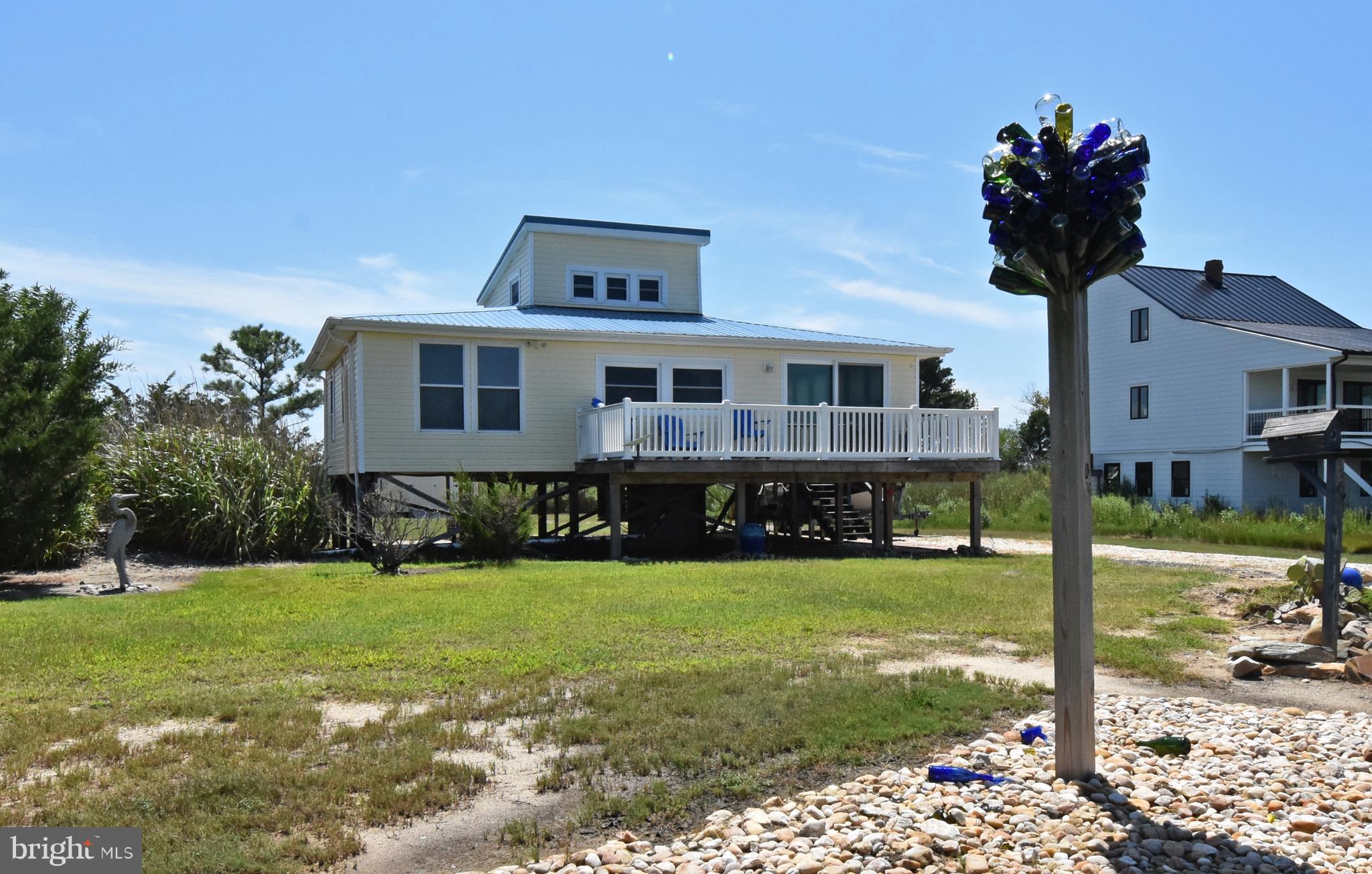 Beautiful waterfront getaway offering gorgeous water views from nearly every window! This charming 2 bed 1 bath, fully furnished home is the perfect weekend retreat, vacation escape, or coastal hideaway. Enjoy waterfront access and the convenience of being within walking distance to the boat ramp, local crab shanties, and restaurant. Outdoor decks on both the front and back of the home provide the perfect spots to relax, entertain, and take in the peaceful waterfront surroundings. There is a 15 ft wide path, which is deeded to this property across the street, that leads to the water.  With approvals from the appropriate authorities, build a pier and boat dock for your enjoyment. The home comes completely furnished and includes a washer, dryer, refrigerator and range —making it truly move-in ready. Additional features include a nitrogen-reducing septic system, vinyl windows, and easy-care laminate flooring. Just bring your bags and start enjoying life by the water!