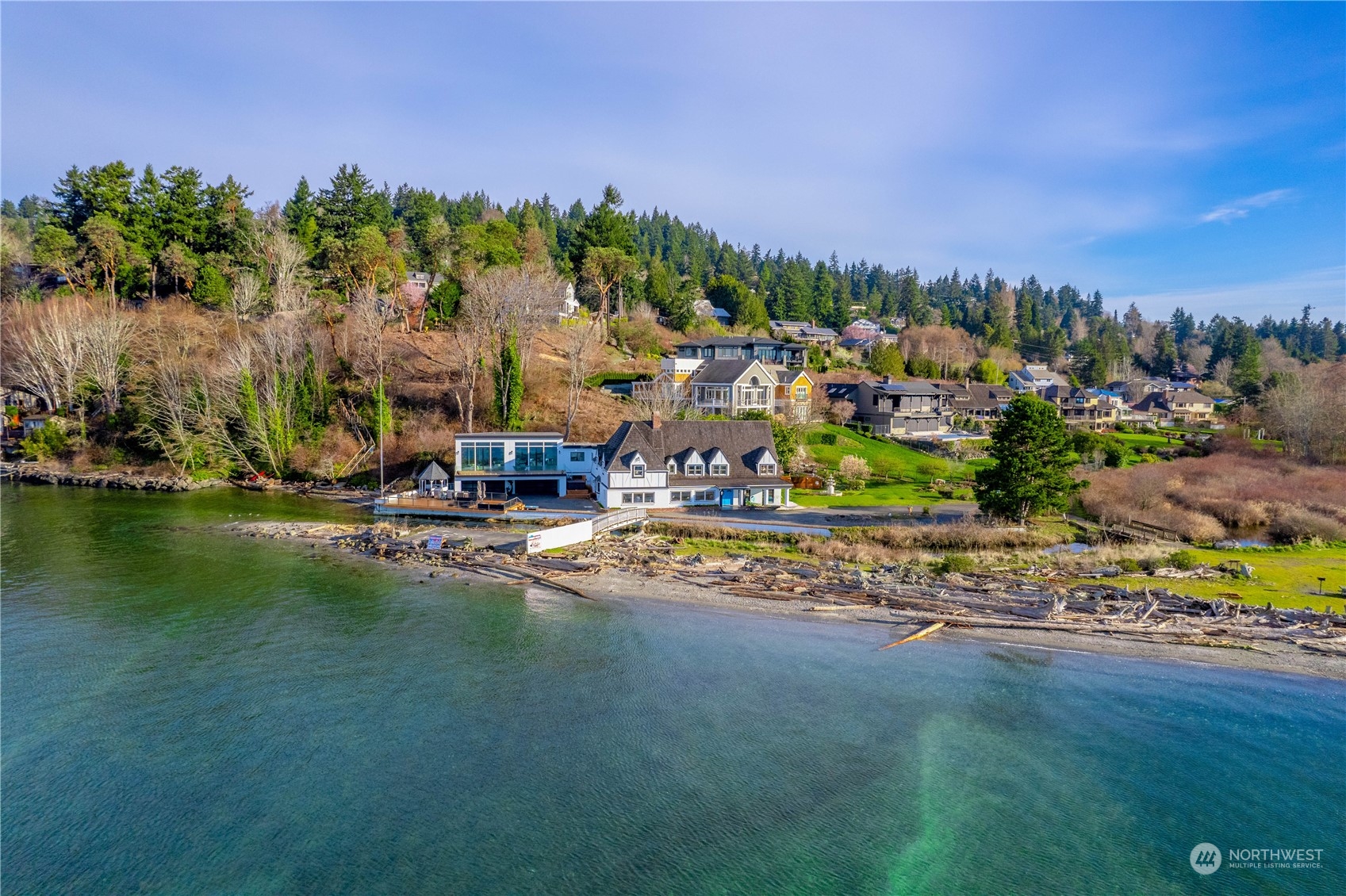 Experience the pinnacle of PNW living in this exquisite waterfront estate in Normandy Park. Nestled along the serene shores of the Puget Sound, this home offers unparalleled 180 degree unobstructed views of Vashon & Maury Islands, Point Robinson Lighthouse & majestic Olympic Mountains. Boasting private helipad, 100 feet of prime Sound waterfront + frontage on Miller Creek, and also adjacent to The Cove—a wildlife sanctuary, this distinctive estate enjoys unparalleled privacy. The home itself is a masterpiece of luxury & design w/large rooms, 4-car gar, boat port & expansive decks that invite large-scale entertaining. Recently enhanced with new 3500 sq ft modern addition, this home seamlessly blends contemporary elegance with timeless charm.