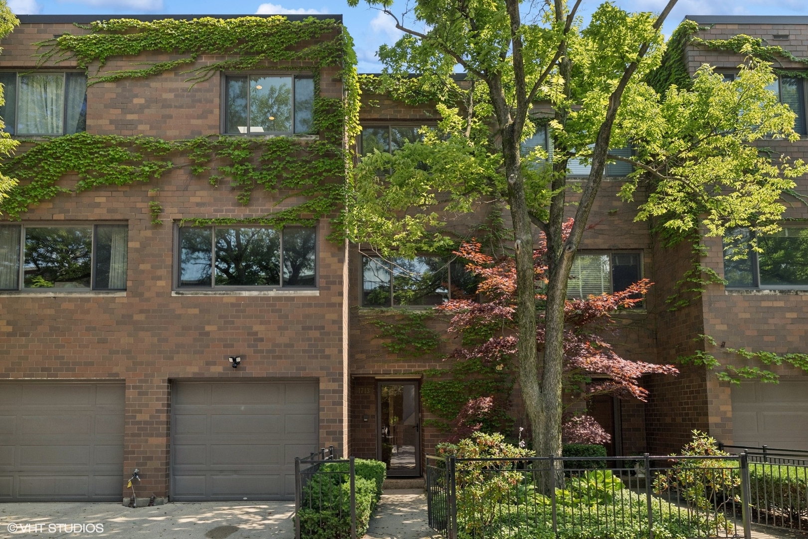 Charming Lincoln Park Townhome with Private Yard in the Coveted Lincoln School District.  At the heart of the main level is a spacious open kitchen with granite counters, abundant cabinetry, stainless steel appliances, and a breakfast bar. A sun-filled breakfast area, framed by a glass atrium, creates the perfect spot for casual dining. The kitchen seamlessly connects to a cozy family room with a fireplace and built-ins, leading directly out to a private, fenced-in backyard with mature trees, brick patio, and a vine-covered privacy wall. From here, a gated pathway opens to a communal arboretum complete with a playground and sandbox, an ideal extension for families and entertaining. The second floor offers a gracious living room with hardwood floors and oversized windows, along with a large primary suite featuring a walk-in closet and ensuite bath with a separate shower. The third floor provides excellent separation of space with two generously sized bedrooms, a Jack-and-Jill bathroom, and a conveniently located laundry room. Additional highlights include an attached one-car garage plus a private parking pad for a second car. With multiple levels, the home offers wonderful separation of living, entertaining, and private spaces.  Ideally located in East Lincoln Park, this residence is within the sought-after Lincoln School District and just moments from shopping, dining, nightlife, grocery stores, Lincoln Park, Lake Shore Drive, and public transportation. Welcome home!